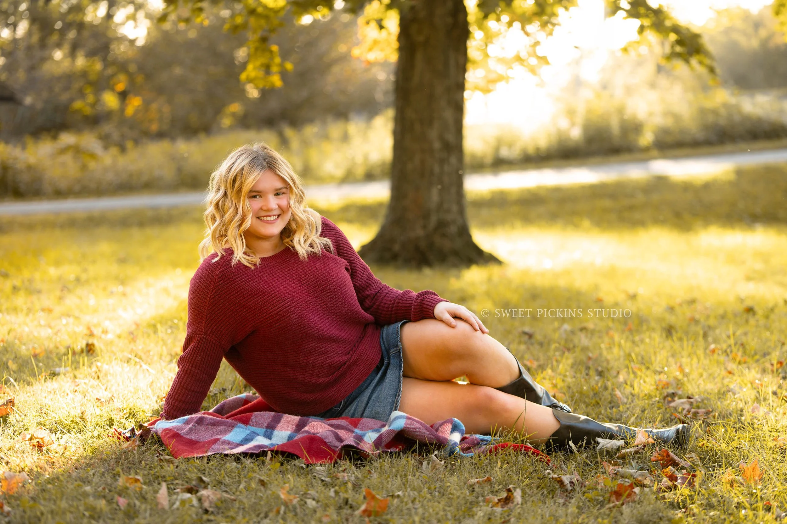Rilynn’s Peru, Indiana Fall Senior Portrait Photography in leaves for Maconaquah High School class of 2027 senior girl wearing maroon sweater and denim skirt by Sweet Pickins Studio senior photographer Amanda Wilson ©
