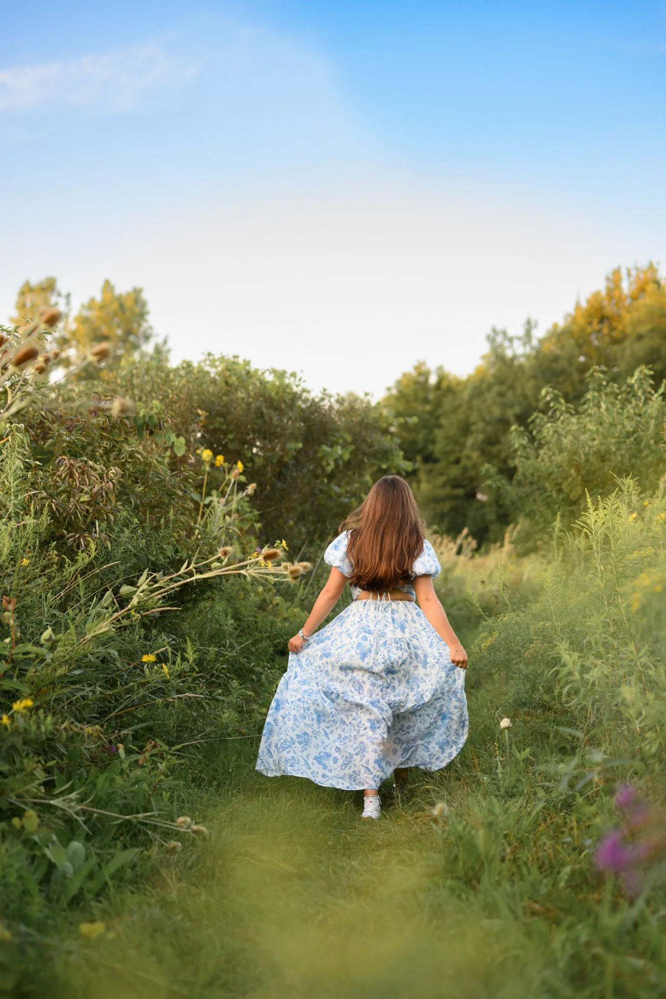 Maisie | Lakeville, Indiana Senior Portrait Photography in Flower Field for Madison East High School class of 2027 senior girl posing in blue floral dress by Peru Indiana senior photographer Amanda Wilson © Sweet Pickins Studio