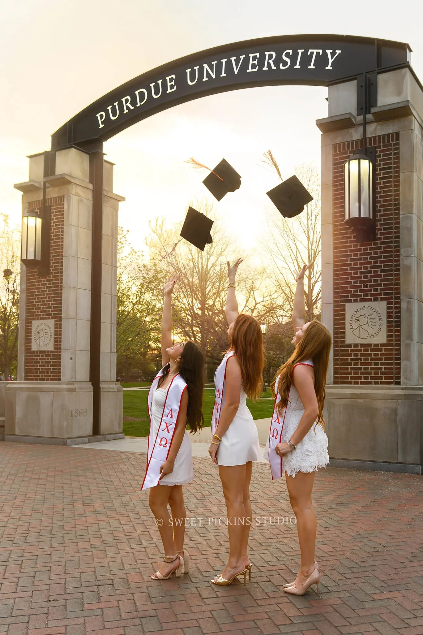 Purdue Graduation Photography for Sorority Sisters in West Lafayette, Indiana by Sweet Pickins Studio photographer Amanda Wilson for graduates tossing caps at Union Arch © 2026