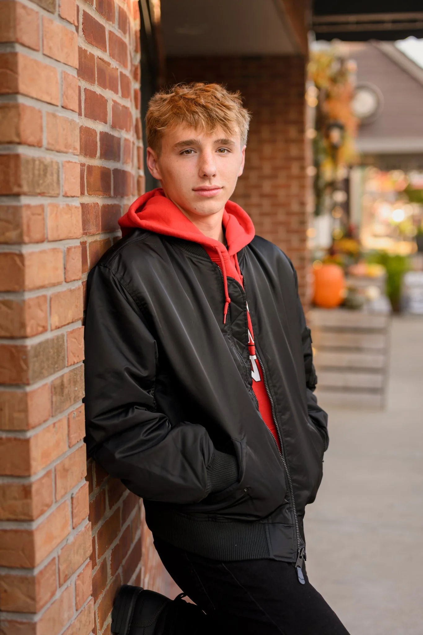 Huntington, Indiana Urban Senior Guy Photography for Huntington North Class of 2027 Senior  BOSTAN walking in urban downtown streets wearing black jacket and hoodie by Sweet Pickins Studio senior photographer Amanda Wilson ©