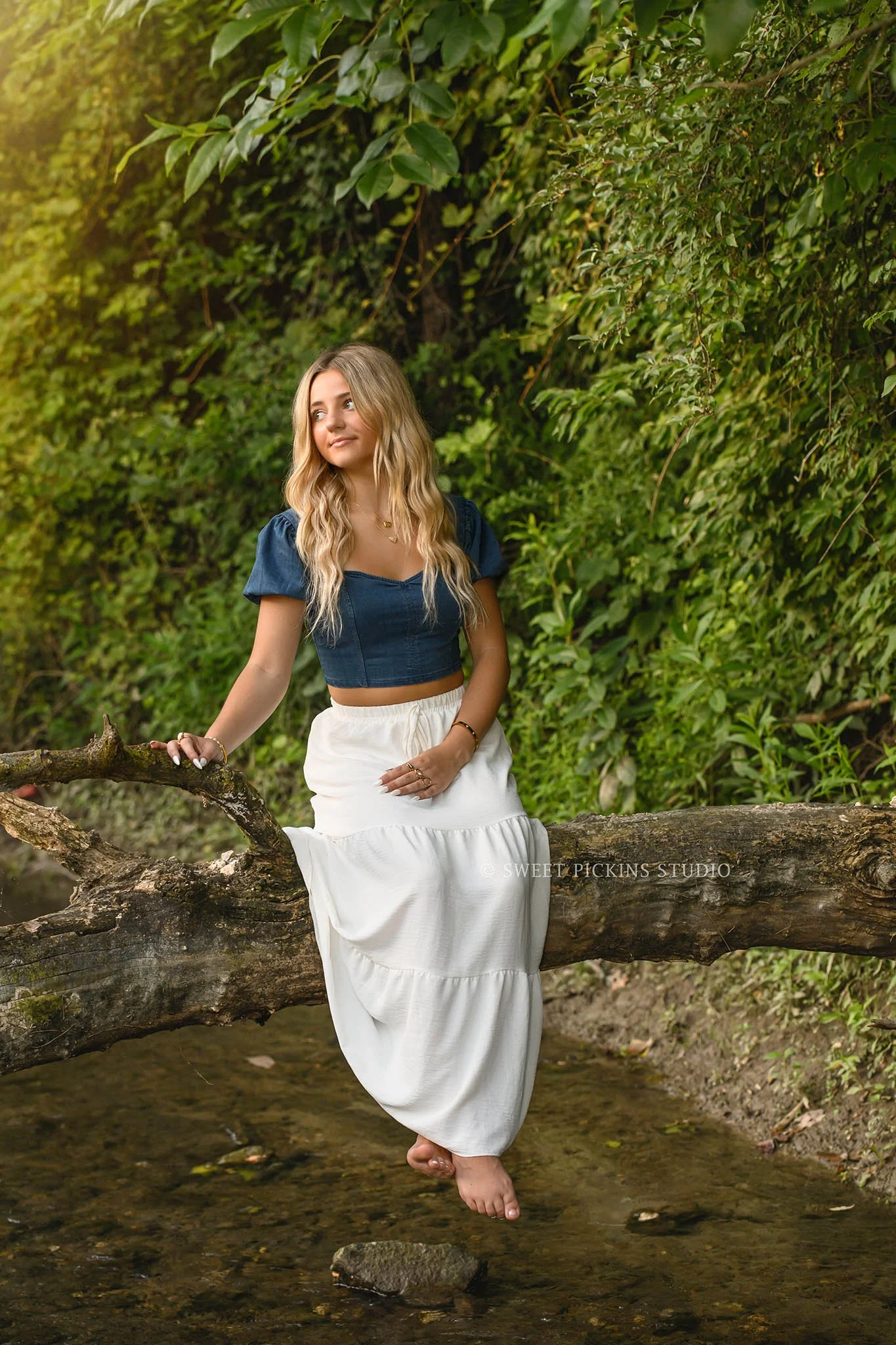 Addison’s Peru, Indiana Country Senior Photography sitting on tree over creek water at Sunset wearing denim top with white flowy skirt by Sweet Pickins Studio senior photographer Amanda Wilson  ©