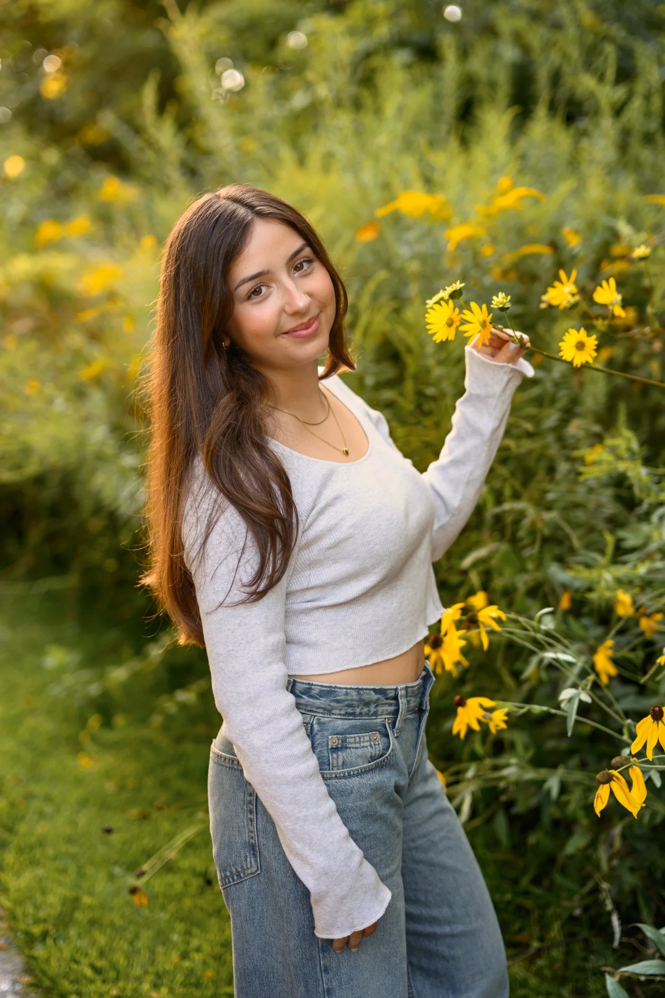 Maisie | Lakeville, Indiana Senior Portrait Photography with yellow wildflowers for Madison East High School class of 2027 senior girl posing in denim jeans and crop top by Peru Indiana senior photographer Amanda Wilson © Sweet Pickins Studio