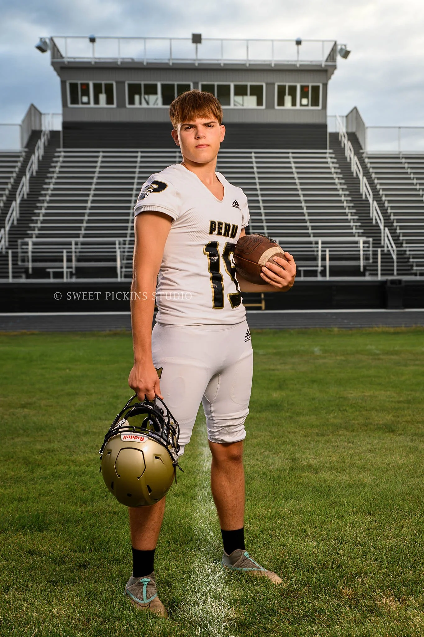 Peru, Indiana sports senior portrait photography for class of 2026 football athlete Xander at stadium in uniform by Sweet Pickins Studio photographer Amanda Wilson ©