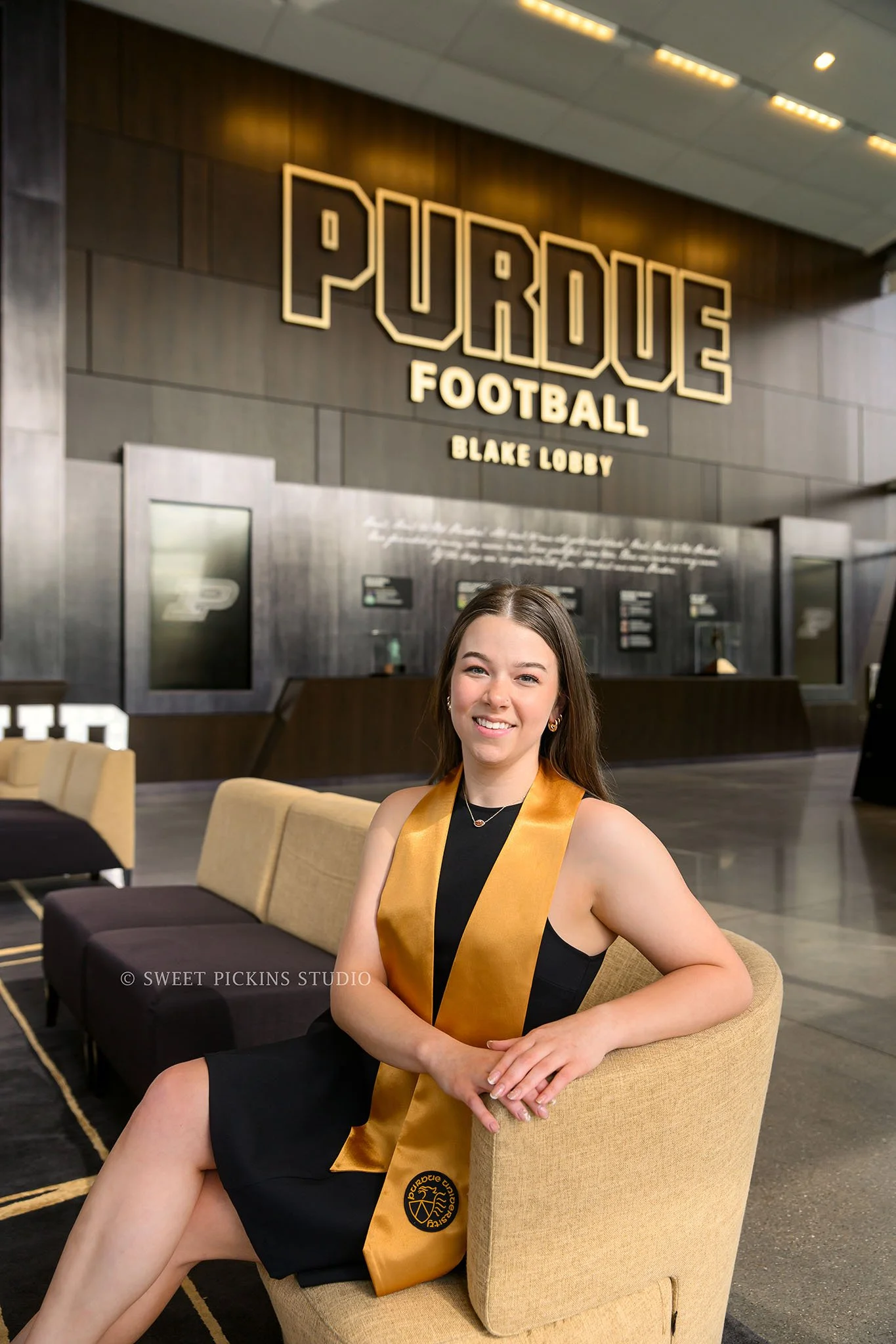 Ashelyn’s Purdue University Graduation Portrait Photography at Boilermaker Blake Lobby with trophies in West Lafayette, Indiana by Sweet Pickins Studio senior photographer Amanda Wilson © 2026