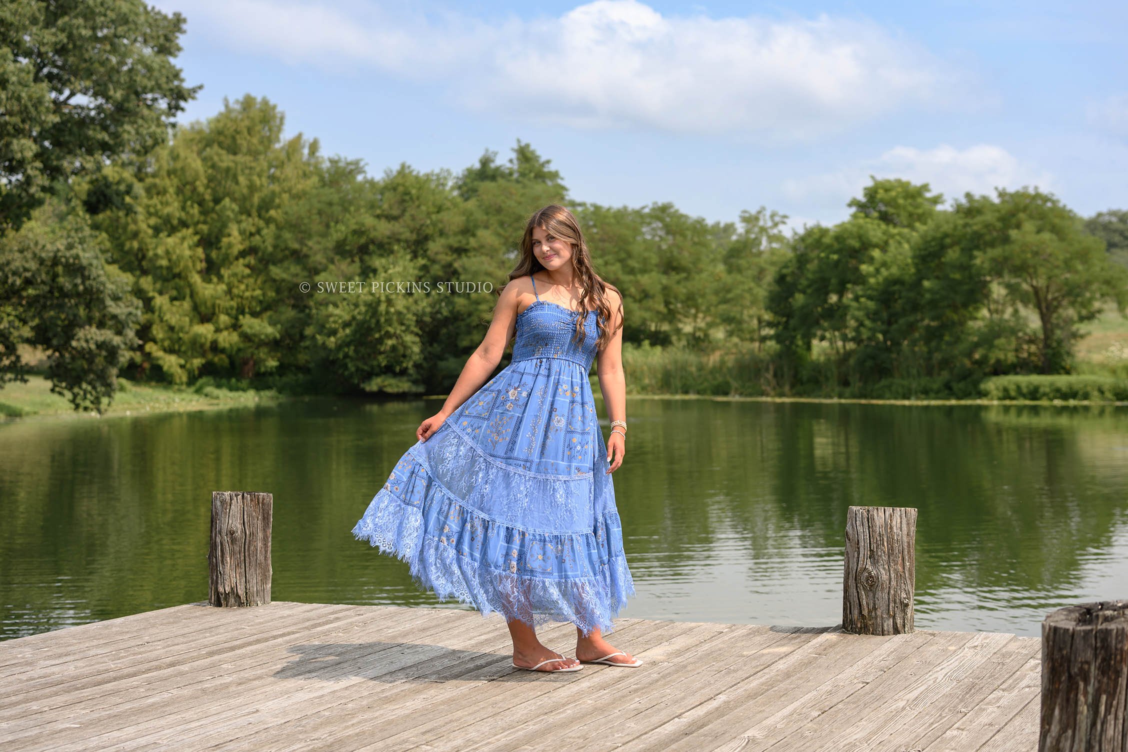 Zionsville, Indiana Senior Photography at Traders Point Creamery with class of 2027 senior girl posing in blue sun dress on wood pier at country pond by Sweet Pickins Studio senior photographer Amanda Wilson ©