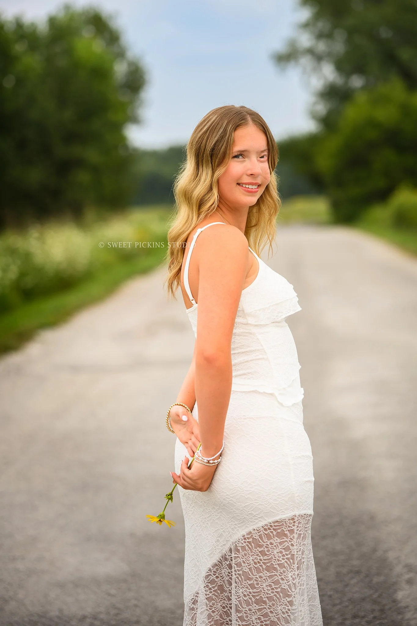 Kilyn’s Noblesville, Indiana Summer Senior Photography for class of 2027 senior girl wearing white tank and denim jeans in flower field location with bouquet by Sweet Pickins Studio senior photographer Amanda Wilson ©