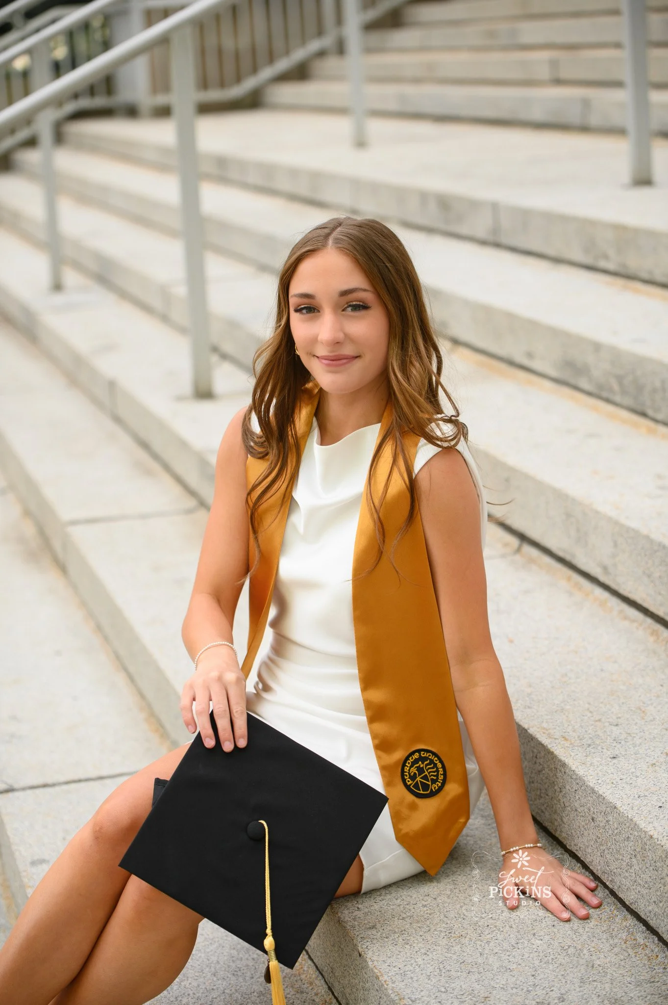 Purdue University Graduation Photography for Twins Class of 2026 Sisters pose at Memorial Union arch in West Lafayette, Indiana by Sweet Pickins Studio senior photographer Amanda Wilson ©