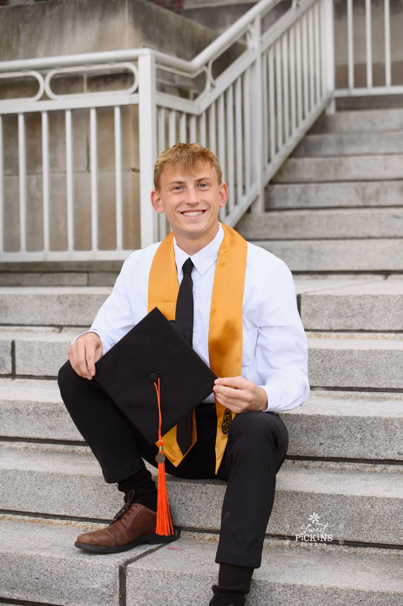 Purdue University Graduation Photography for Guy in Cap and Gown sitting on steps in West Lafayette by Sweet Pickins Studio senior photographer Amanda Wilson ©