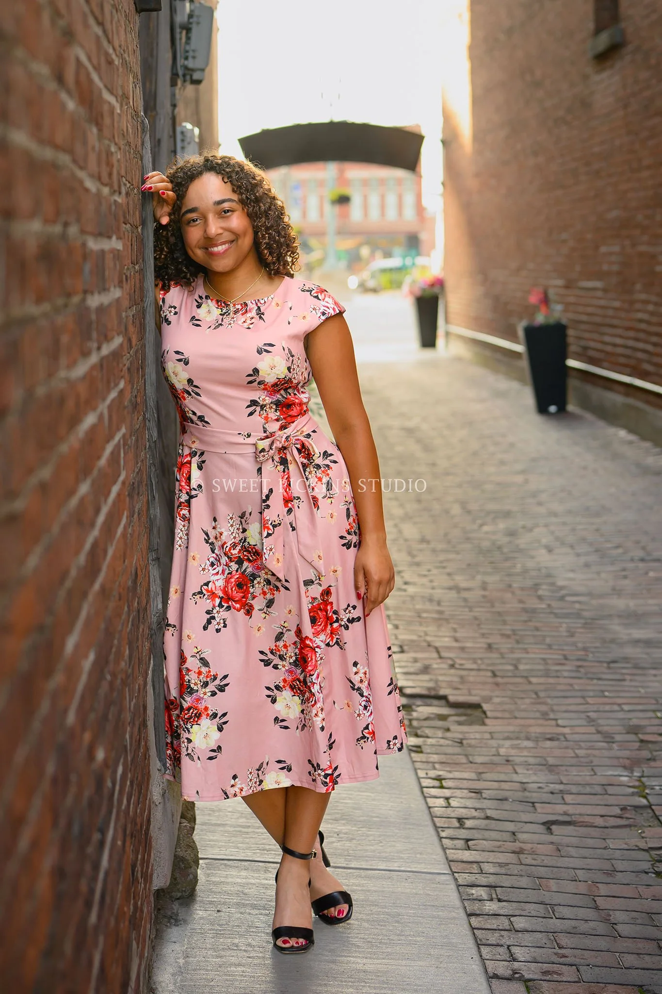 Piercey ‘s Peru, Indiana Senior Photography in pink floral dress for Class of 2027 senior girl in downtown urban alley by Sweet Pickins Studio senior photographer Amanda Wilson ©