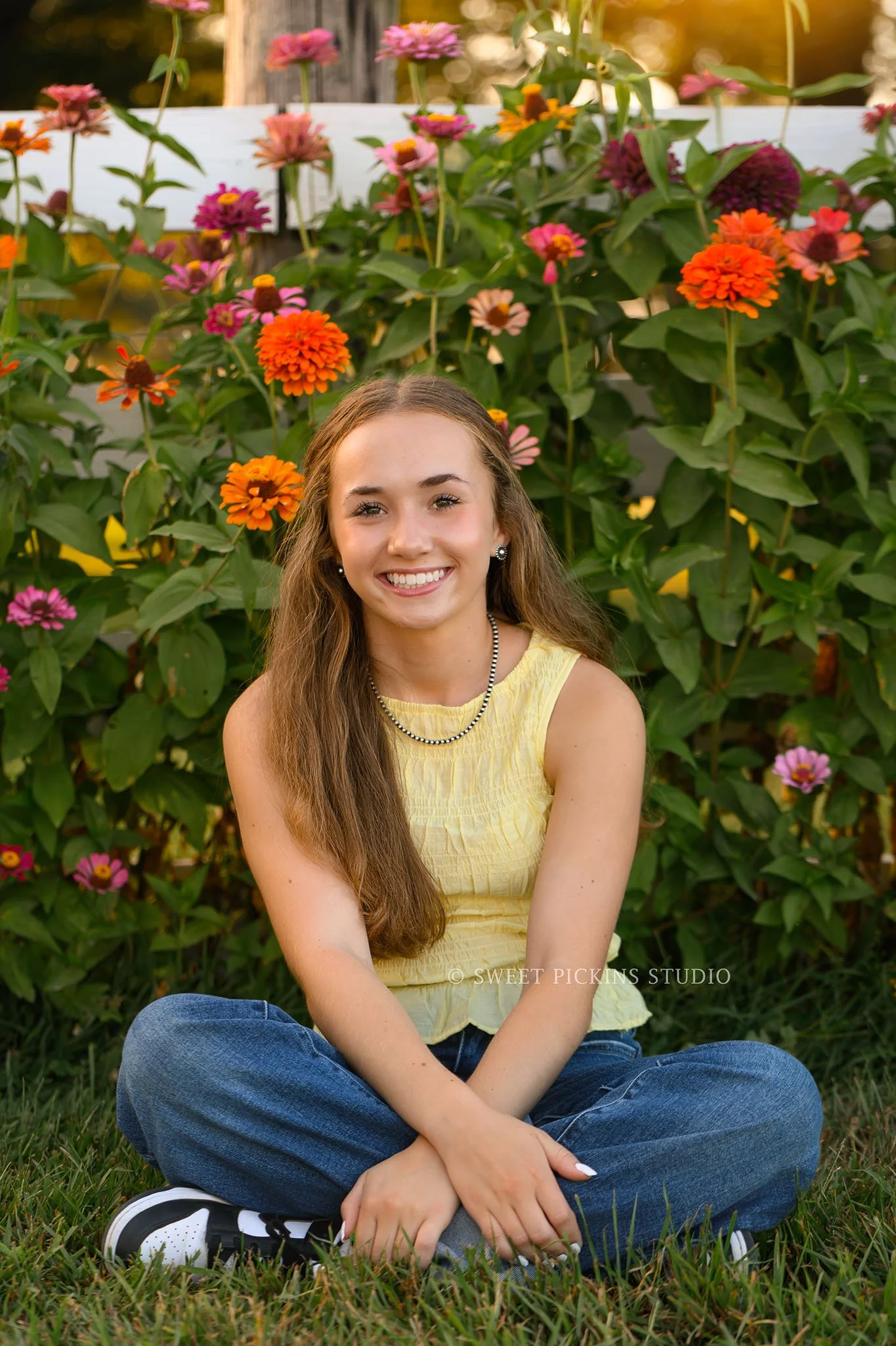 Natalie’s Lowell, Indiana Floral Senior Photography for class of 2027 senior girl posing with colorful zinnia flowers by red barn at  family farm by Sweet Pickins Studio senior photographer Amanda Wilson ©