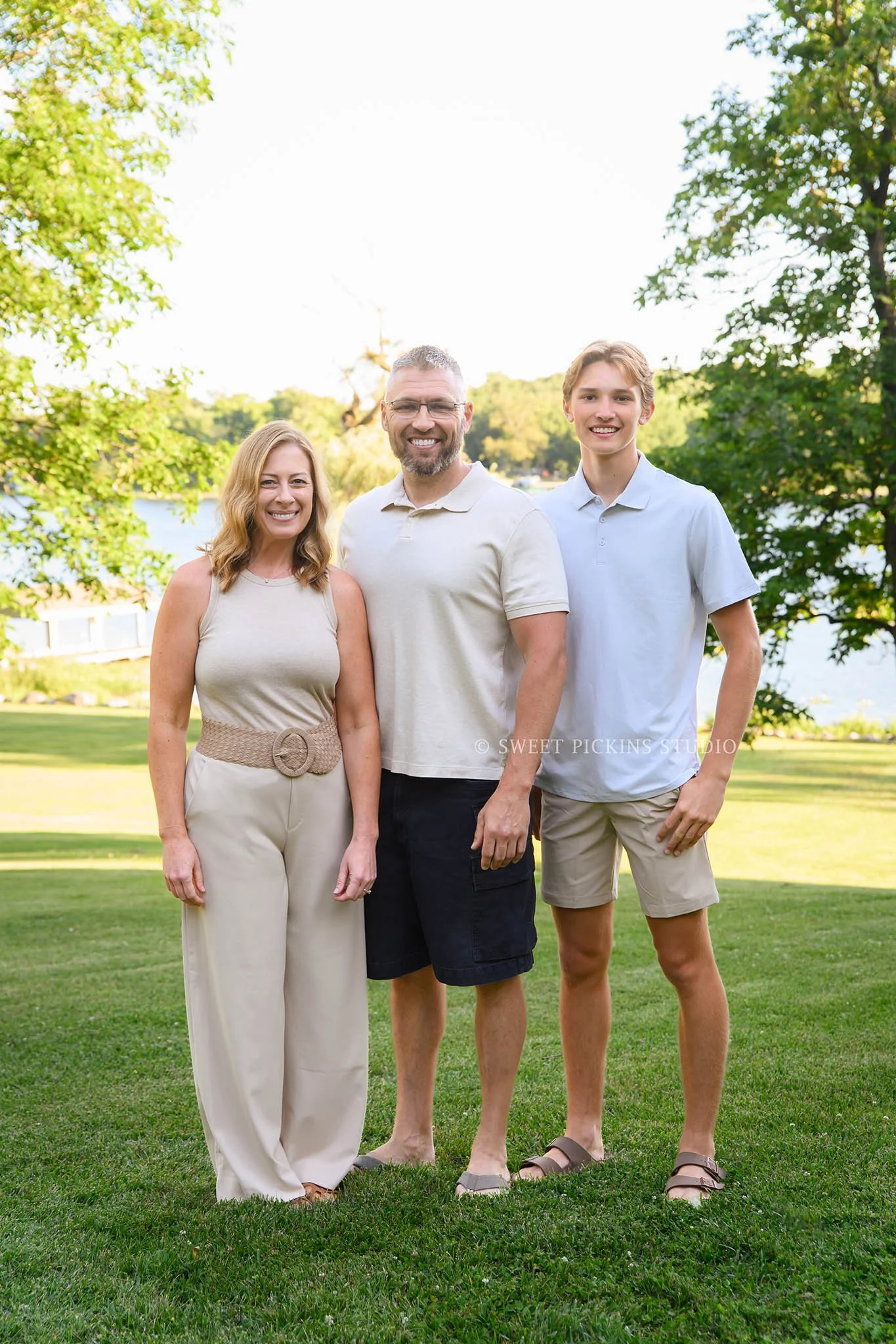 Roann, Indiana Family Portrait Photography of family of 3 wearing blue and beige outfits at Luken’s Lake outdoor nature location in summer by Sweet Pickins Studio family photographer Amanda Wilson ©