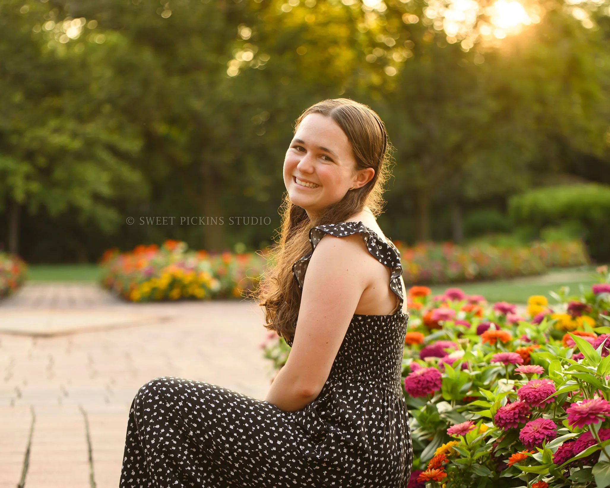 Downtown Carmel, Indiana Senior Photography for Class of 2027 Senior Ellen with colorful zinnia flowers wearing floral romper in summer by Sweet Pickins Studio senior photographer Amanda Wilson ©