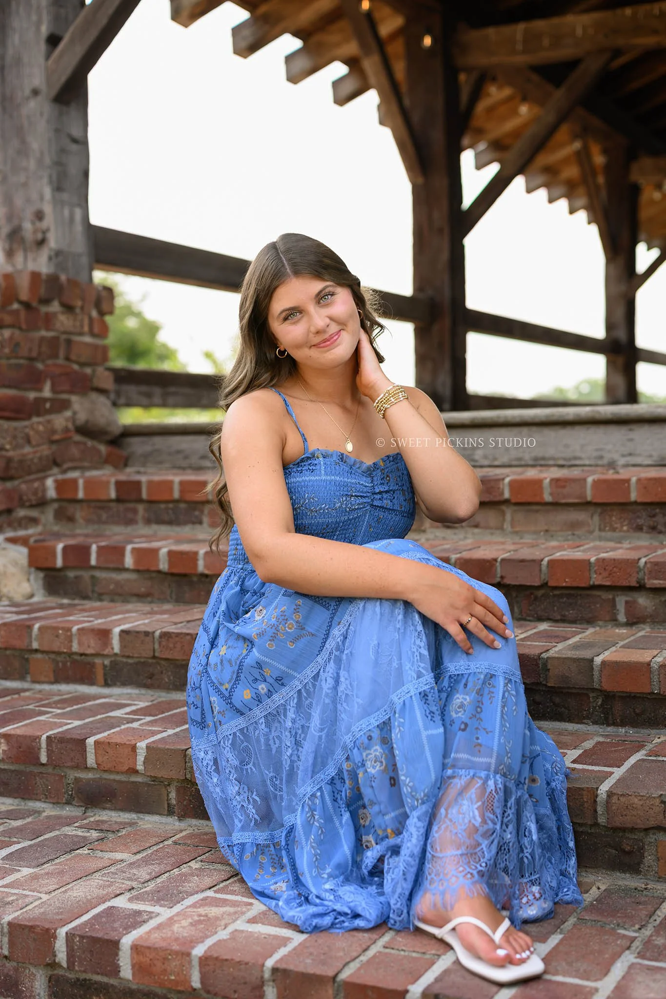 Zionsville, Indiana Senior Photography at Traders Point Creamery with class of 2027 senior girl posing in blue sun dress at barn by Sweet Pickins Studio senior photographer Amanda Wilson ©