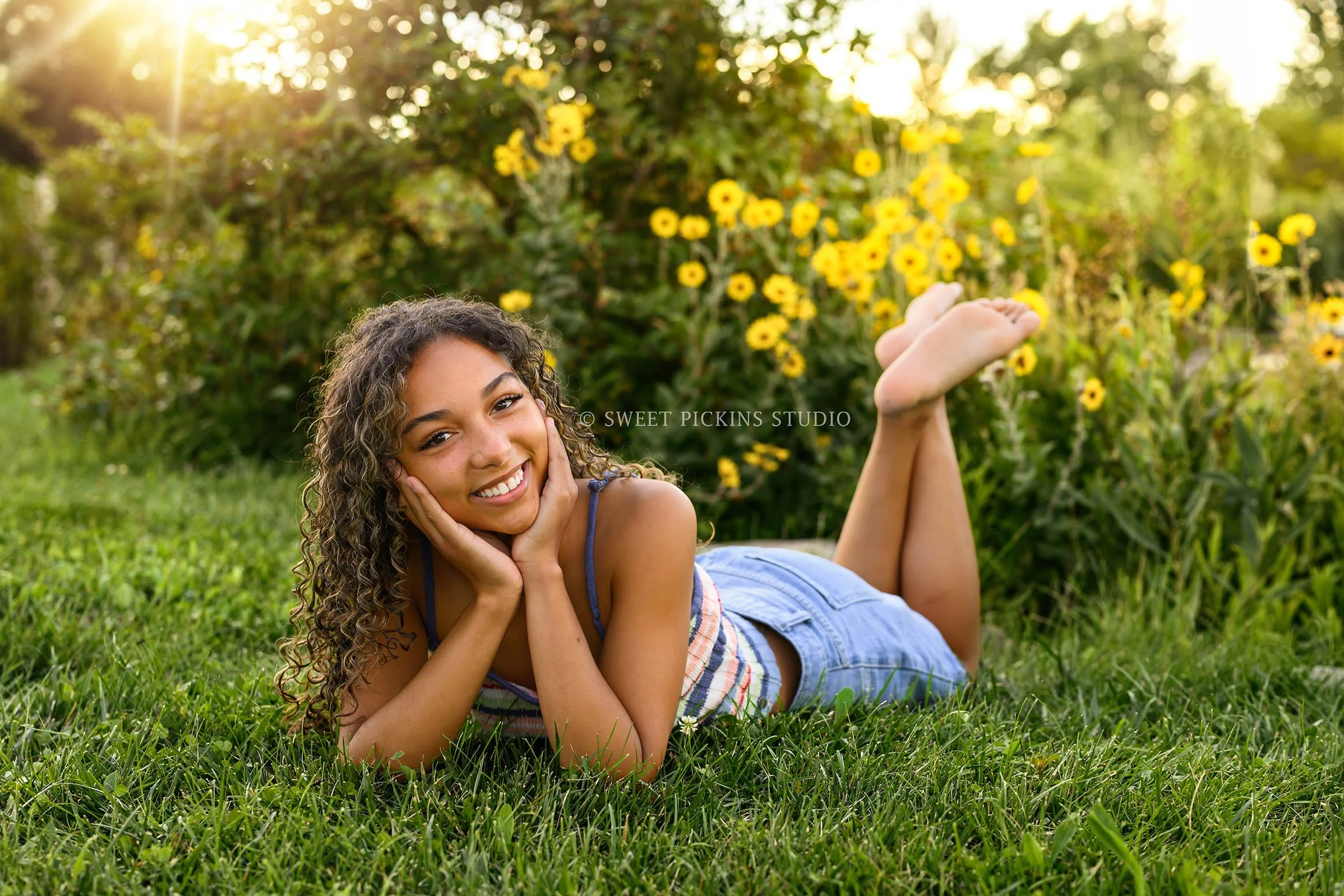 Madeline | Senior Girl Photography posing in colorful tank top and denim jean shorts near yellow flowers by Peru Indiana Senior  photographer Amanda Wilson of Sweet Pickins Studio ©
