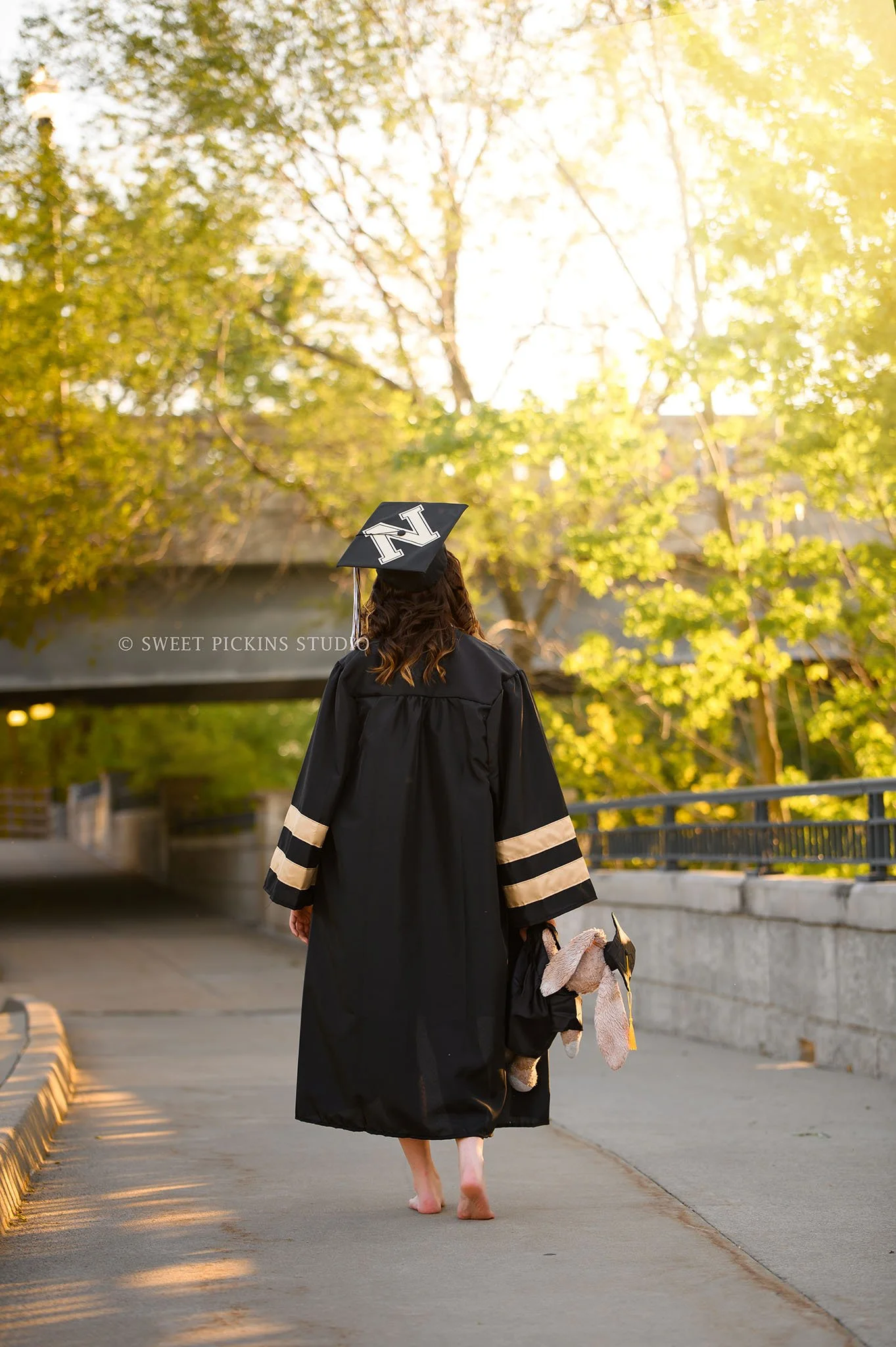 Hailee | Noblesville High School Graduation Photography in Cap and Gown in Downtown Nature location for class of 2026 senior girl with stuffed animal by Sweet Pickins Studio senior photographer Amanda Wilson ©