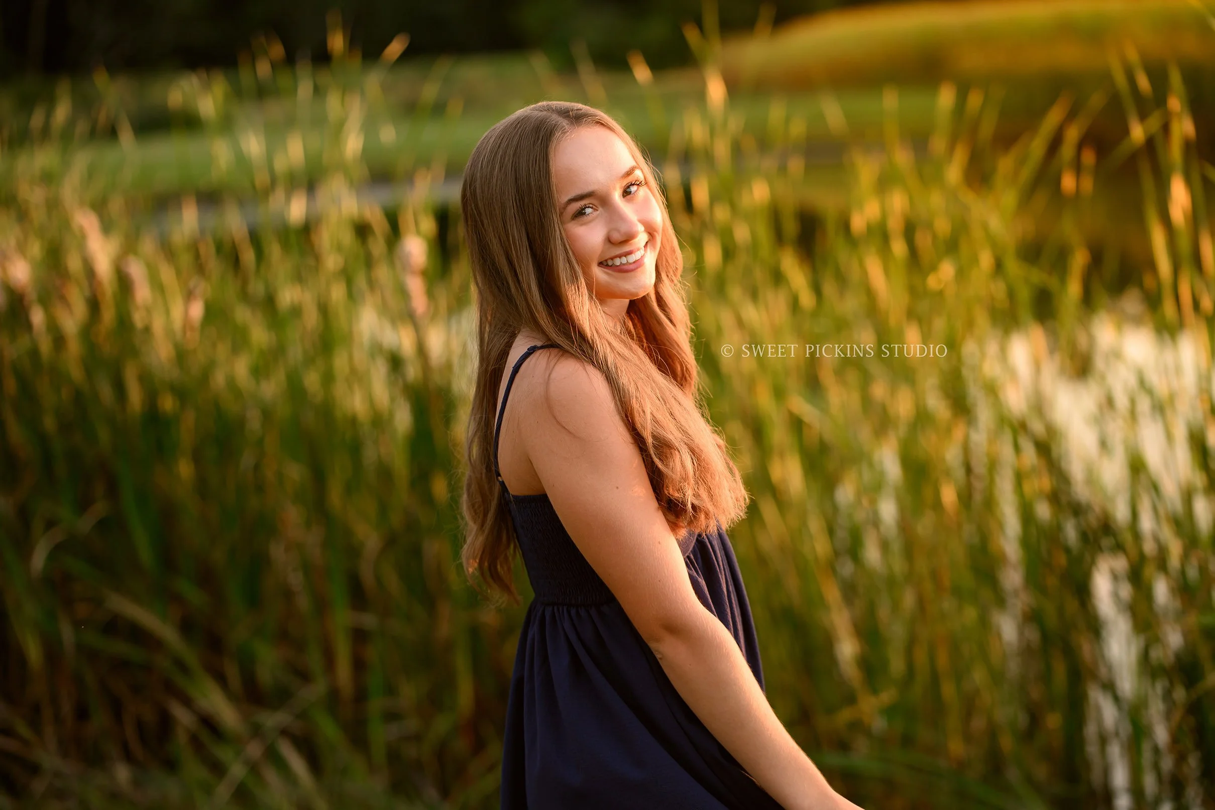 Natalie’s Lowell, Indiana Senior Photography posing in blue dress by pond at sunset on farm by Sweet Pickins Studio senior photographer Amanda Wilson ©