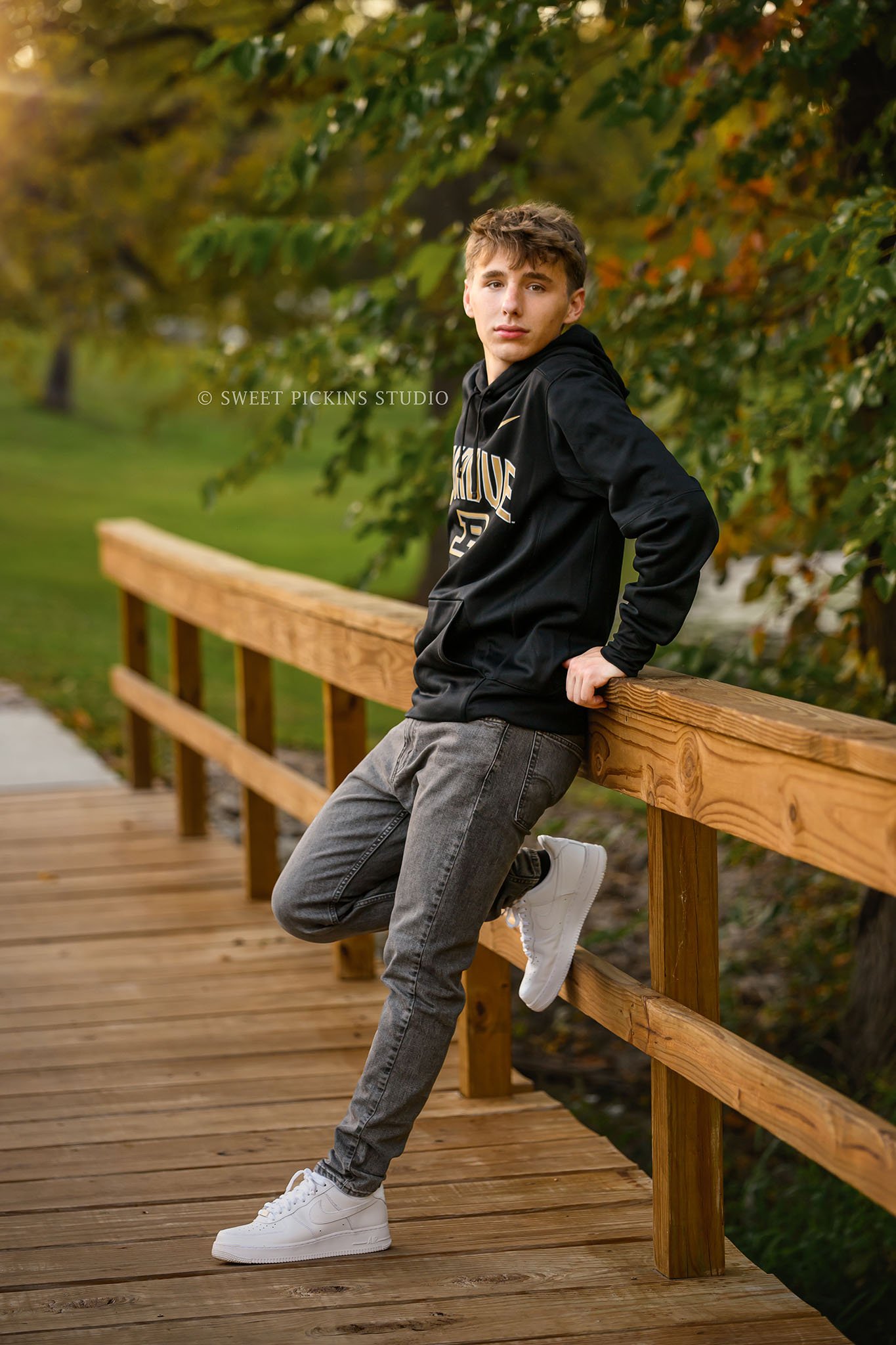 Huntington, Indiana Senior Picture Photography for Huntington North Class of 2027 Senior Guy BOSTAN posing in Purdue hoodie at outdoor nature park by lake by Sweet Pickins Studio senior photographer Amanda Wilson ©