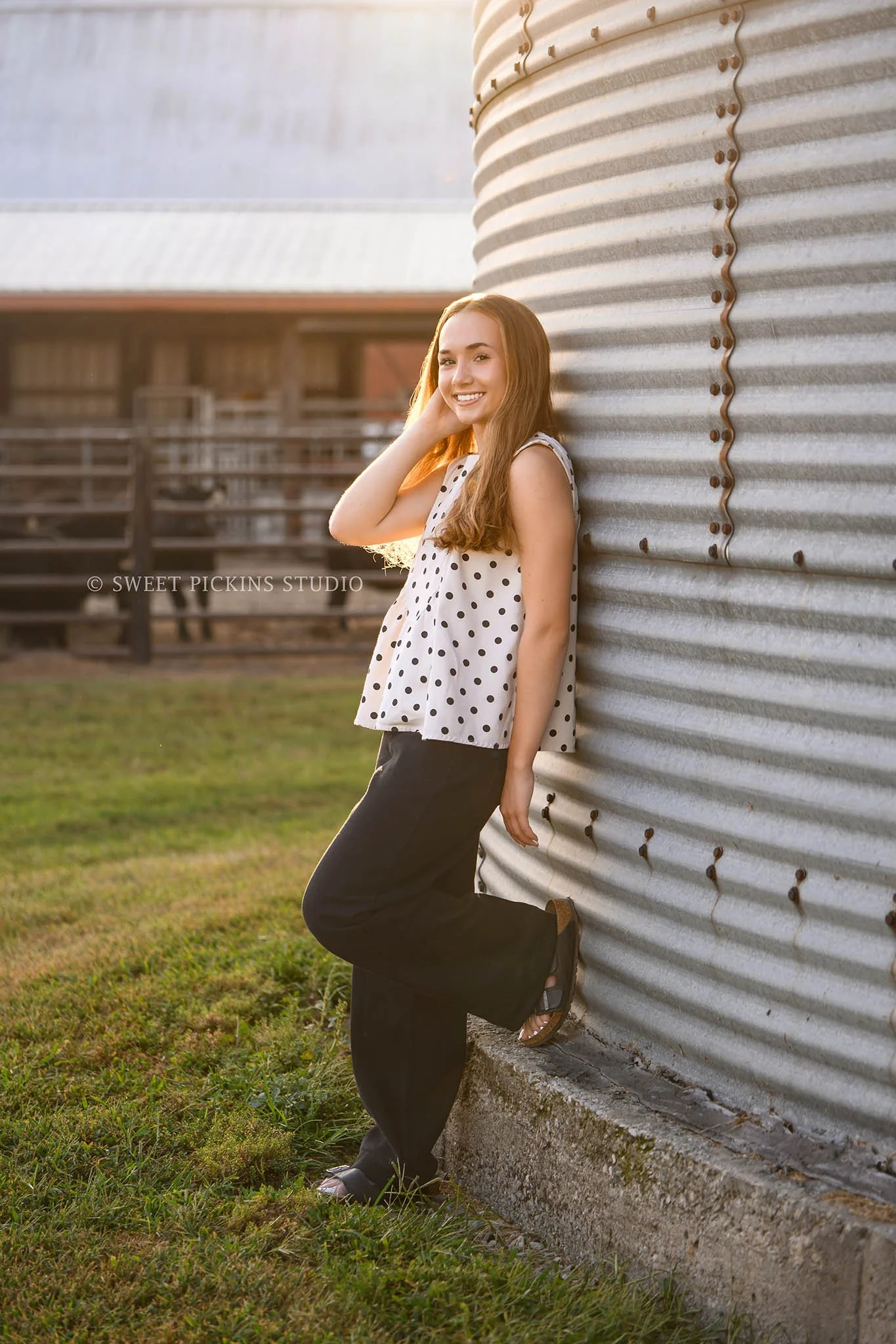 Natalie’s Lowell, Indiana Farm Senior Photography for class of 2027 senior girl posing by grain bin and red cattle barn at farm by Sweet Pickins Studio senior photographer Amanda Wilson ©
