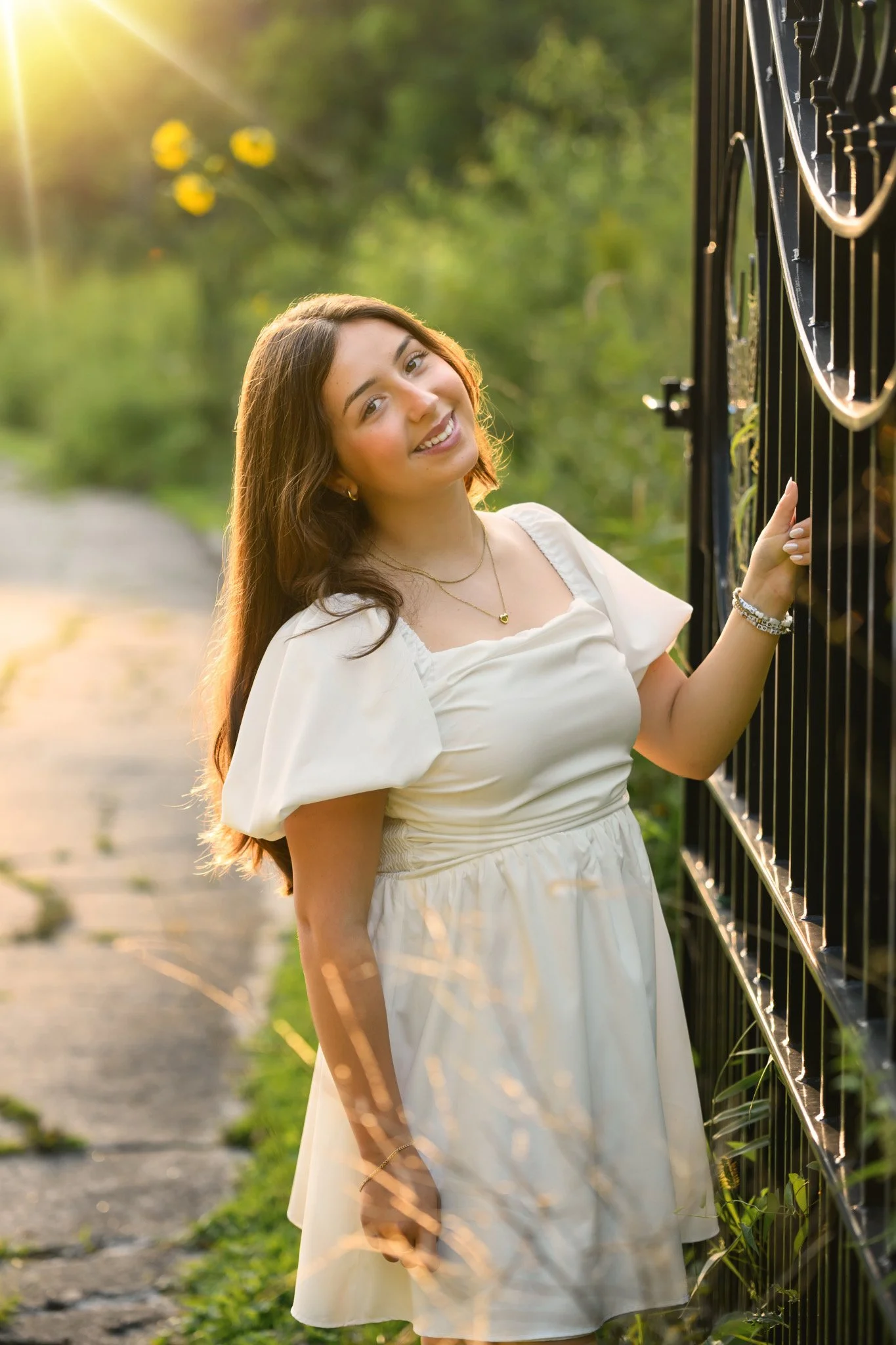 Maisie | Lakeville, Indiana Senior Pictures for Madison East High School class of 2027 senior girl posing in white dress by black gate by Peru Indiana senior photographer Amanda Wilson © Sweet Pickins Studio