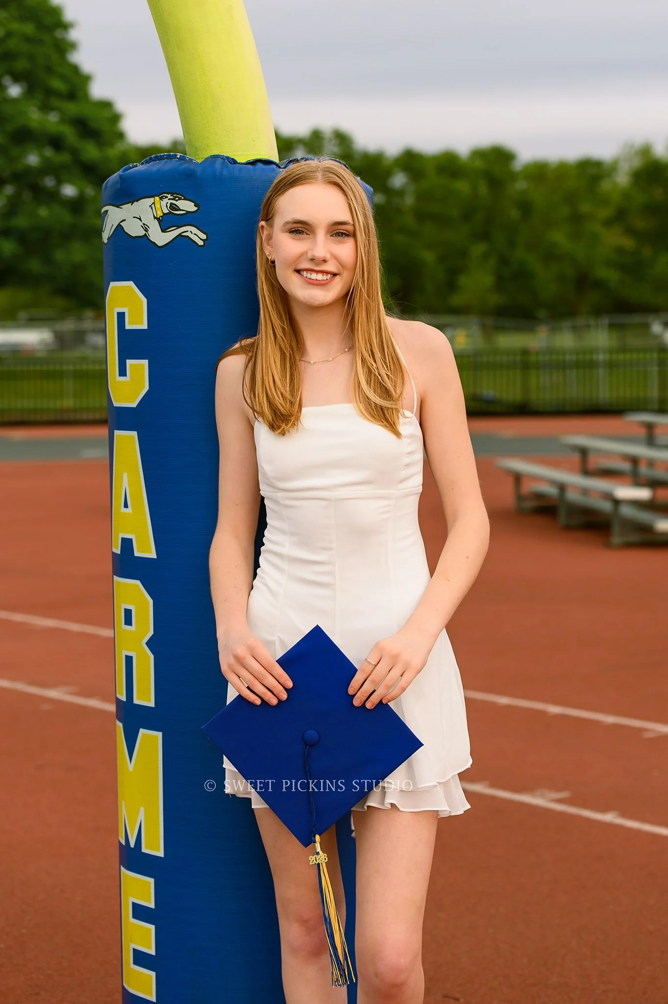 Holly and Taylor’s Carmel High School Graduation Photography in Cap and Gown at football field by Sweet Pickins Studio senior photographer Amanda Wilson ©