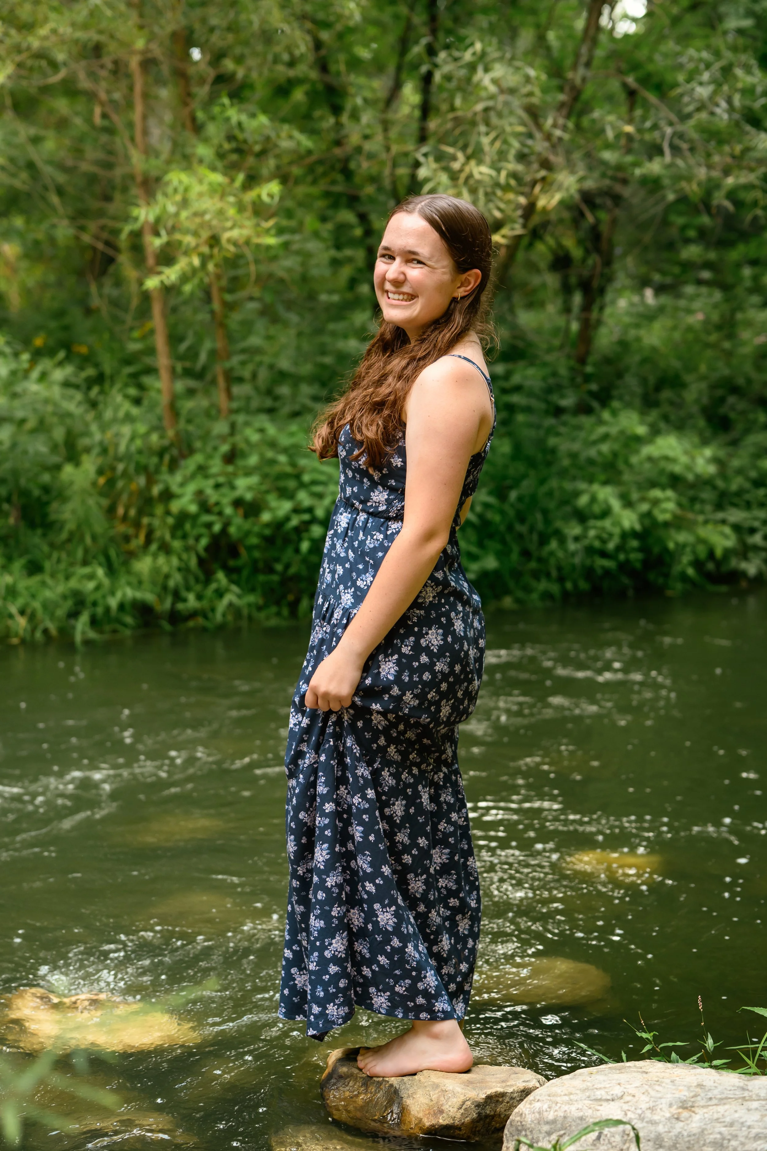 Carmel, Indiana Senior Photography for Class of 2027 Senior Ellen in Creek water wearing floral romper in summer by Sweet Pickins Studio senior photographer Amanda Wilson ©
