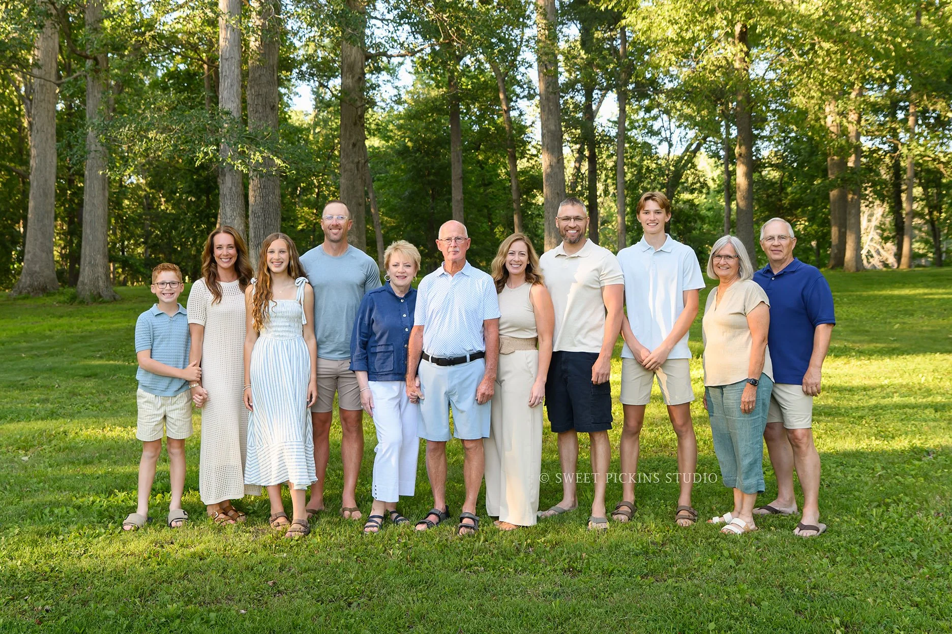 Roann, Indiana Extended Family Photography for Large Group of 11 wearing blue and beige outfits at Luken’s Lake outdoor nature location with trees by Sweet Pickins Studio family photographer Amanda Wilson ©