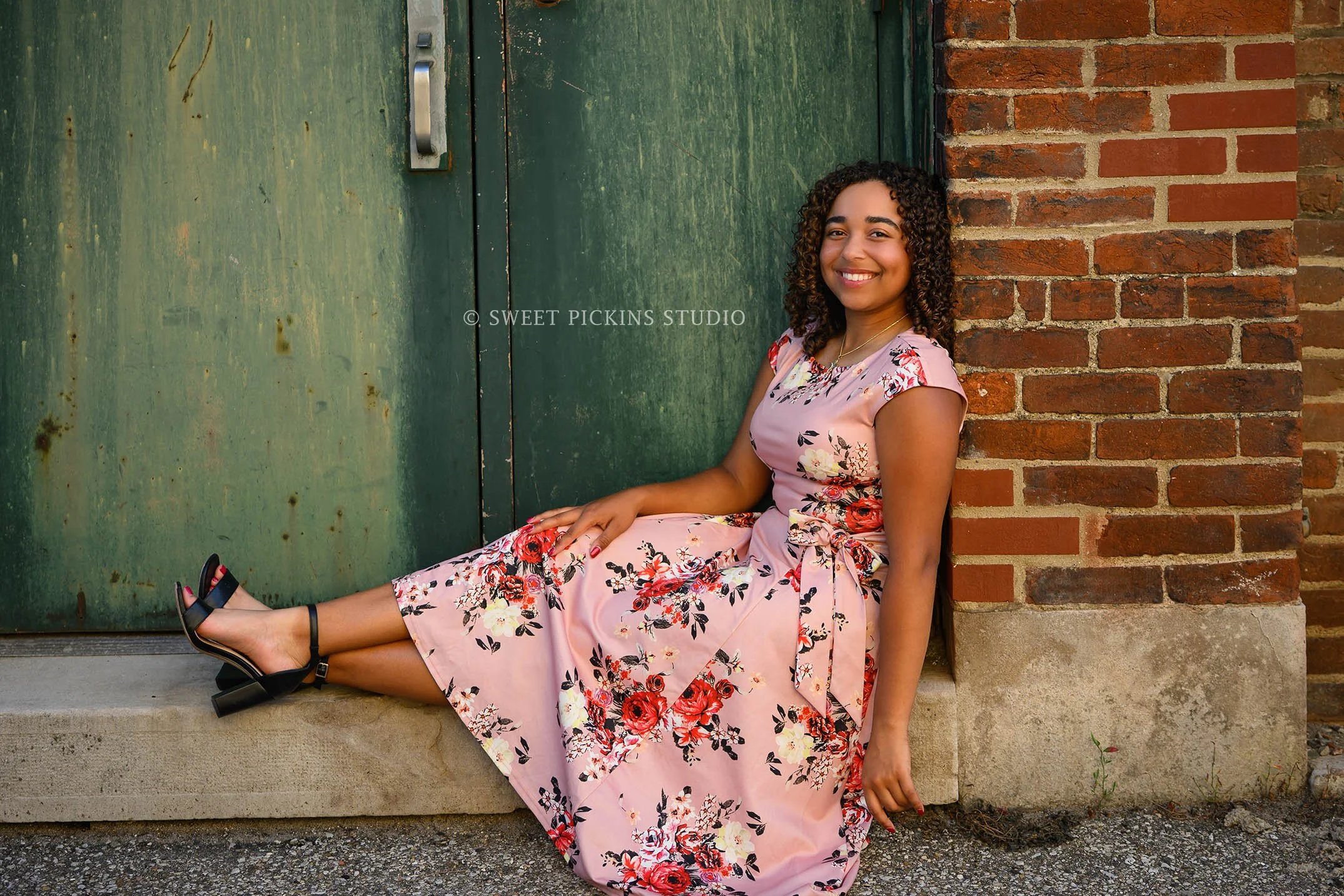 Peru, Indiana Senior Girl Photography for Class of 2027 PIERCEY wearing pink floral dress in downtown alley by green door by Sweet Pickins Studio senior photographer Amanda Wilson ©