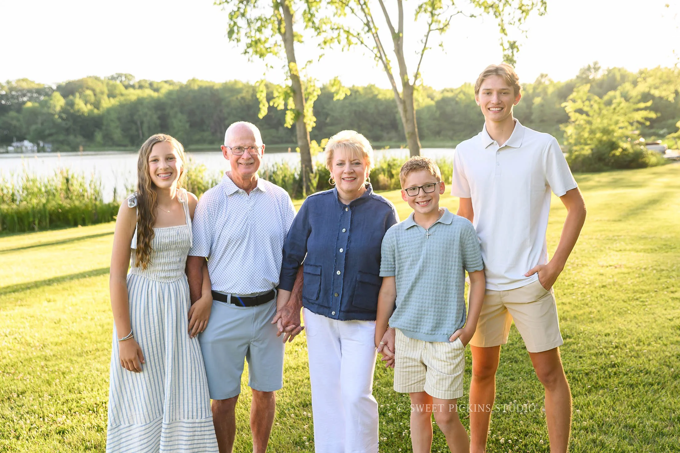 Roann, Indiana Grandparent Photography of grandparents with grandchildren wearing blue and beige outfits at Luken’s Lake outdoor nature location in summer by Sweet Pickins Studio family photographer Amanda Wilson ©
