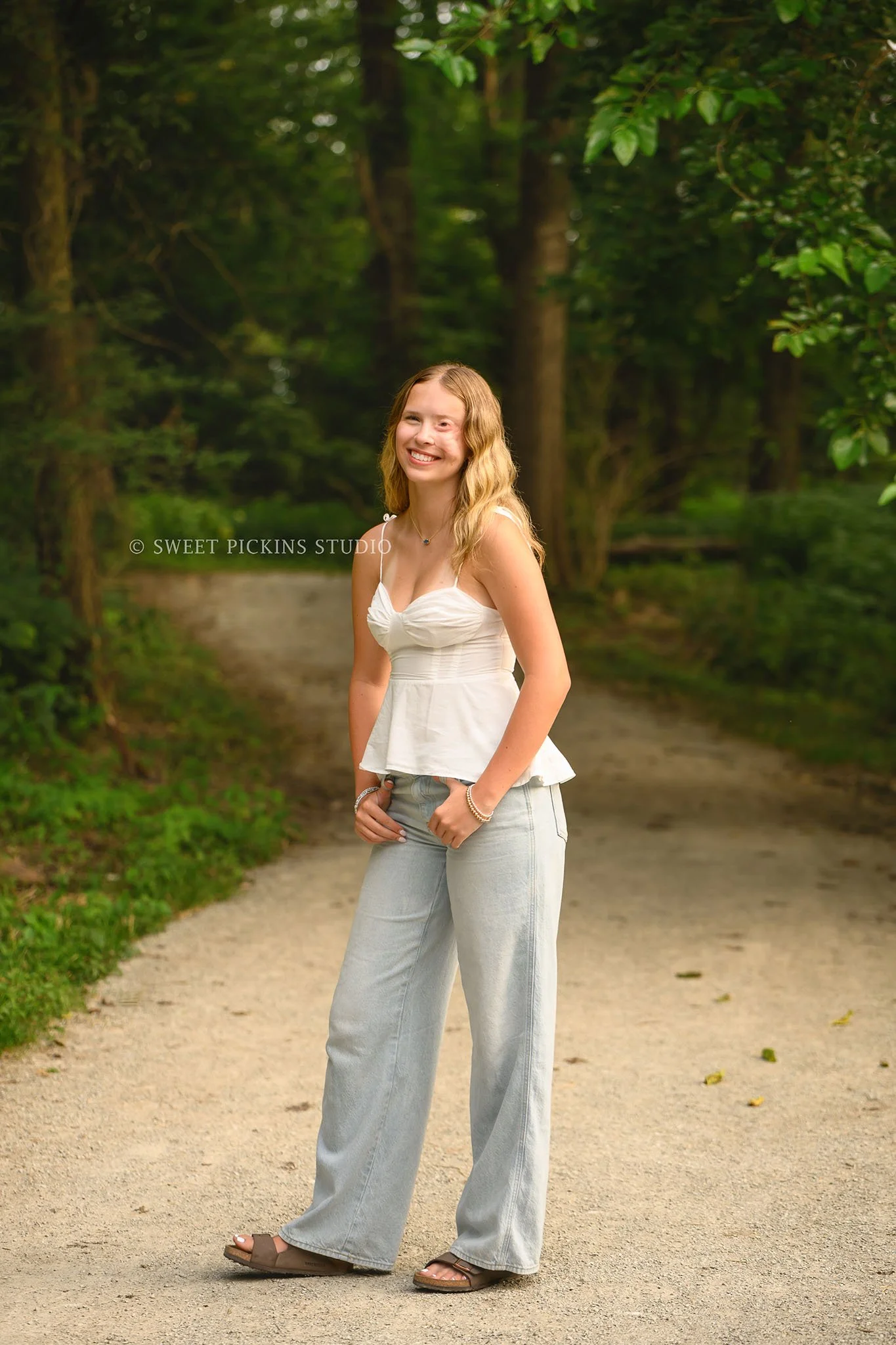 Kilyn’s Noblesville, Indiana Summer Senior Photography for class of 2027 senior girl wearing white tank and denim jeans in forest location by Sweet Pickins Studio senior photographer Amanda Wilson ©