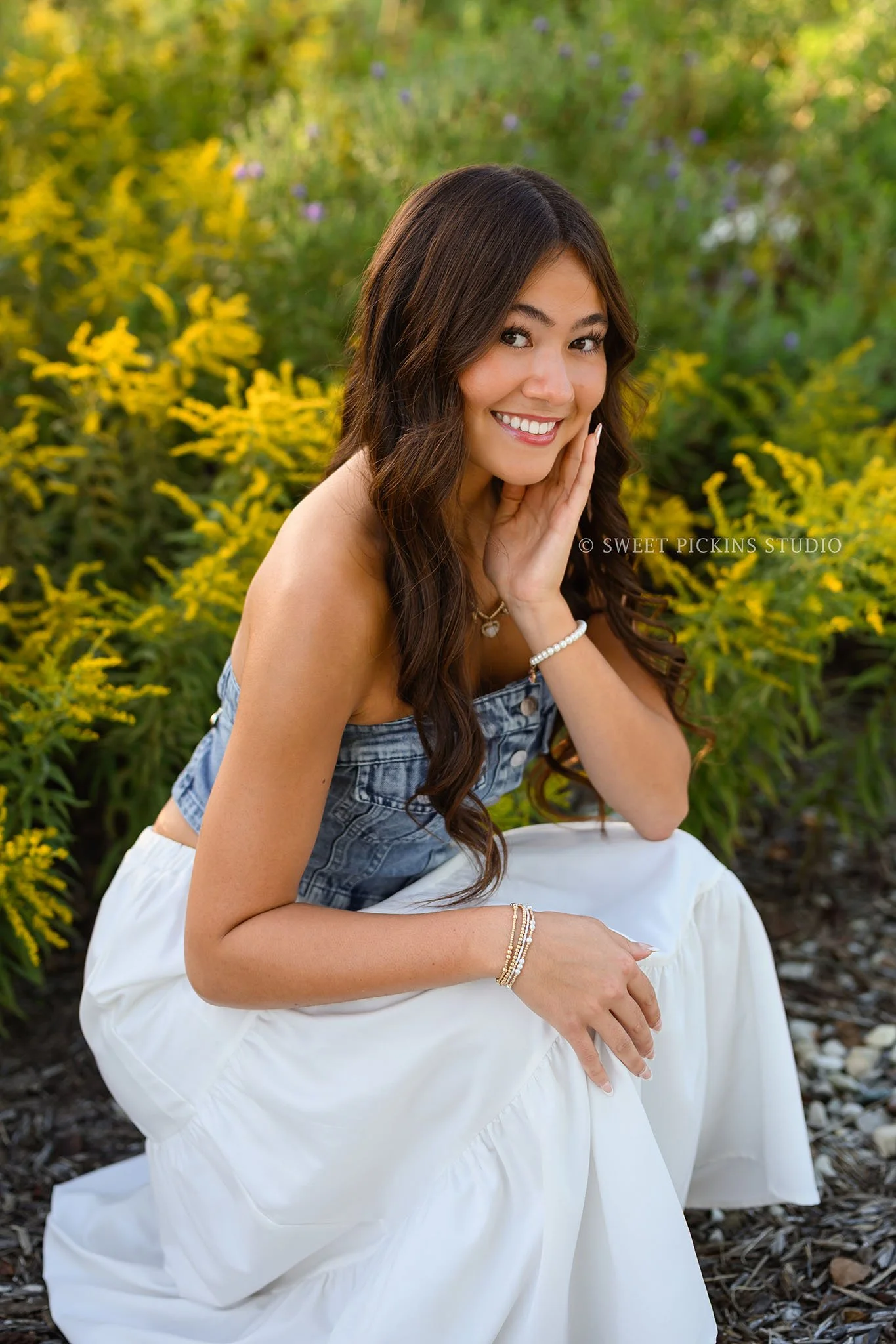 Rachel | Carmel, Indiana Floral Senior Pictures in Garden at sunset for Class of 2027 senior girl wearing denim crop top and white skirt by goldenrod by Sweet Pickins Studio senior photographer Amanda Wilson ©