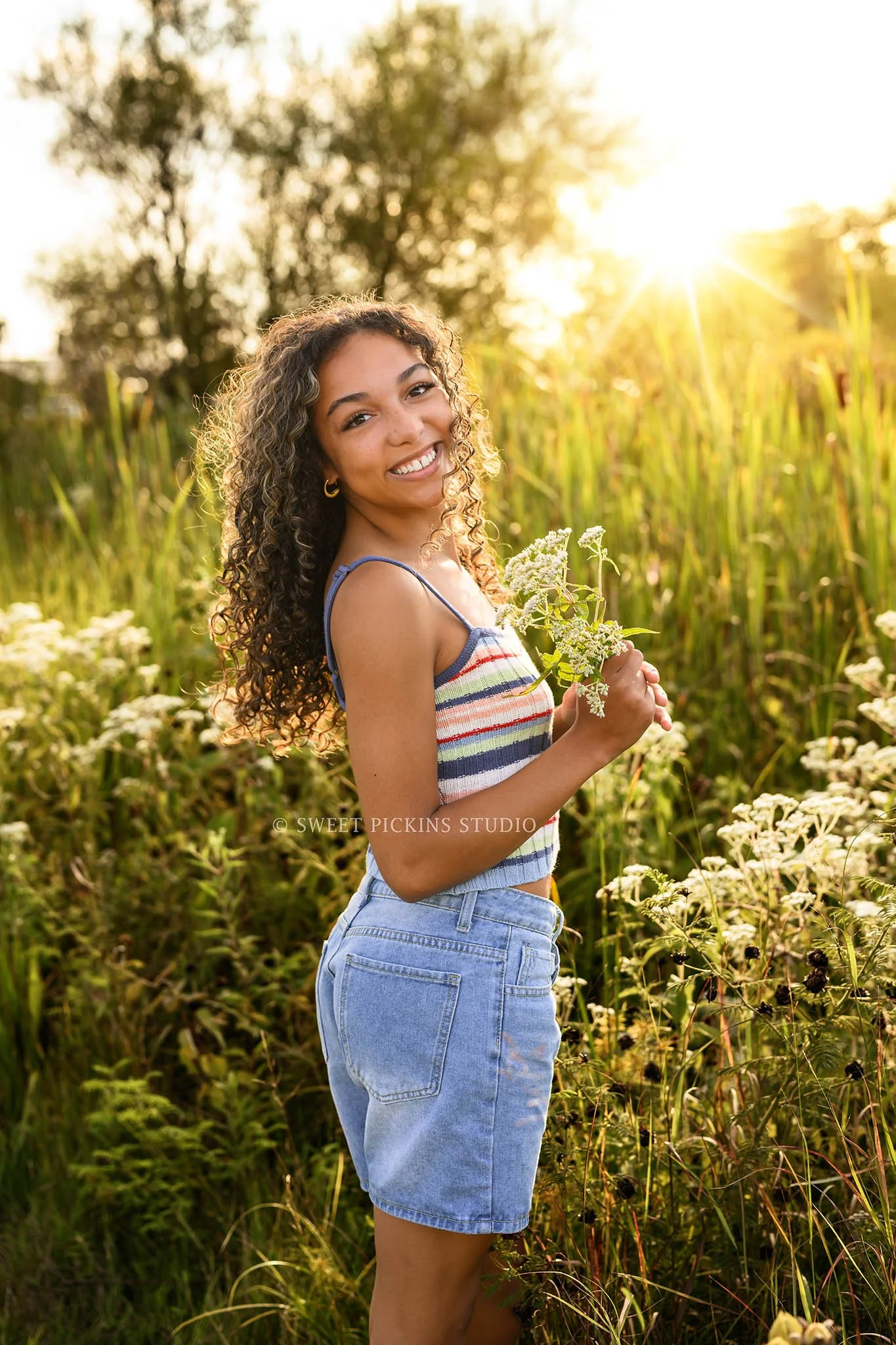Madeline | Indiana Senior Girl Photography posing in flower field for Speedway High School Class of 2027 wearing striped tank top and denim shorts by Sweet Pickins Studio senior photographer Amanda Wilson ©