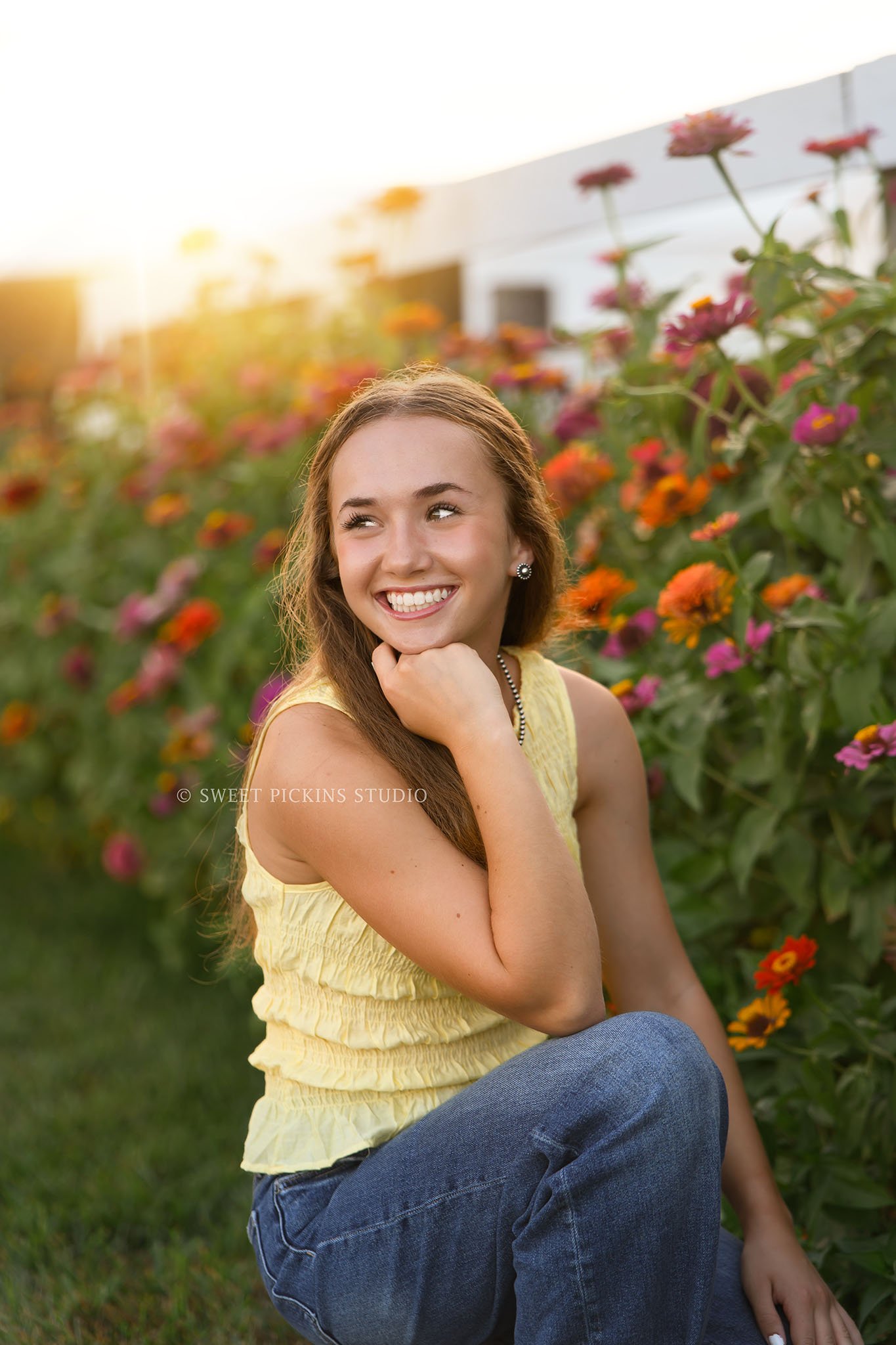 Natalie’s Lowell, Indiana Floral Senior Photography for class of 2027 senior girl posing with colorful zinnia flowers by red barn at  family farm by Sweet Pickins Studio senior photographer Amanda Wilson ©
