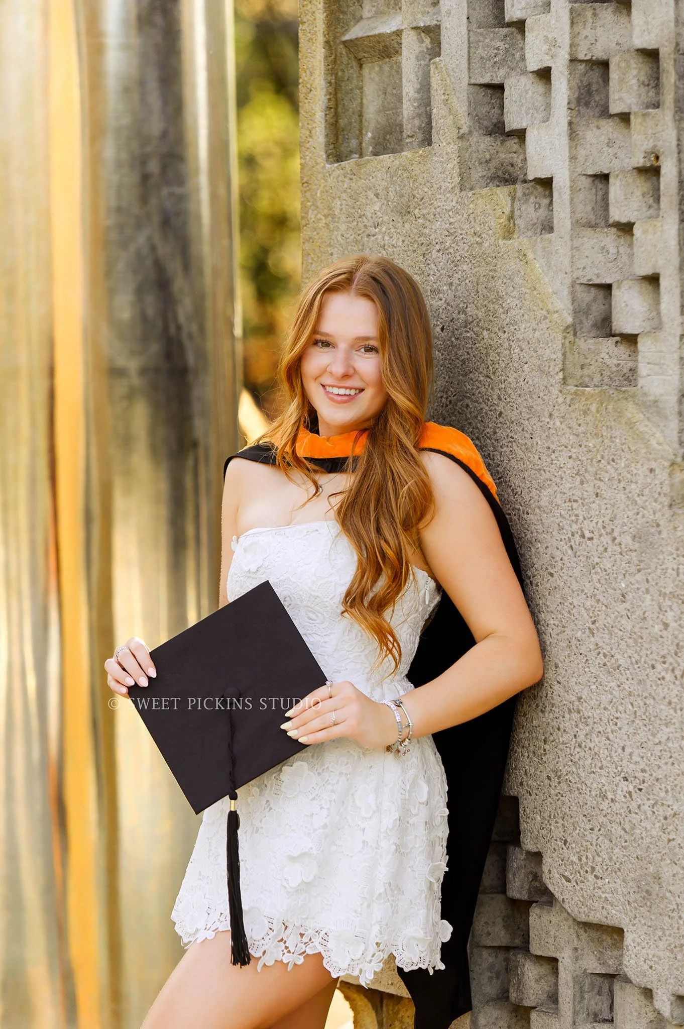 Lauren’s Purdue Graduation Photography in West Lafayette, Indiana by Sweet Pickins Studio photographer Amanda Wilson for spring graduate posing in white dress at Engineering Fountain with grad cap and tassel © 2026