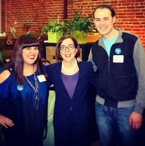 DEVON WORKED TO HELP PASS THE CLEAN FUELS STANDARD, A KEY LAW to reduce OREGON'S CLIMATE FOOTPRINT. PICTURED HERE CELEBRATING THE LAW'S PASSAGE WITH HER HUSBAND, BRYCE, AND GOVERNOR KATE BROWN.