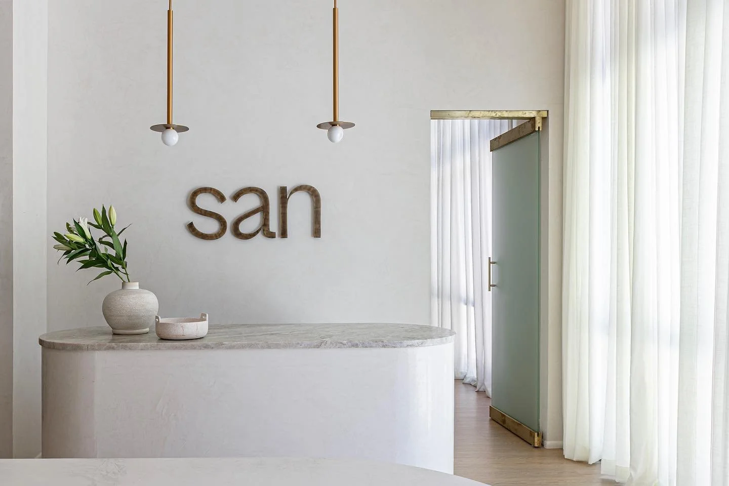 We kept things light and airy in the retail space with a plaster finish throughout, unlacquered brass accents, honed travertine, and creamy sheer draperies 🤍 Photographed by @bonseyephotography