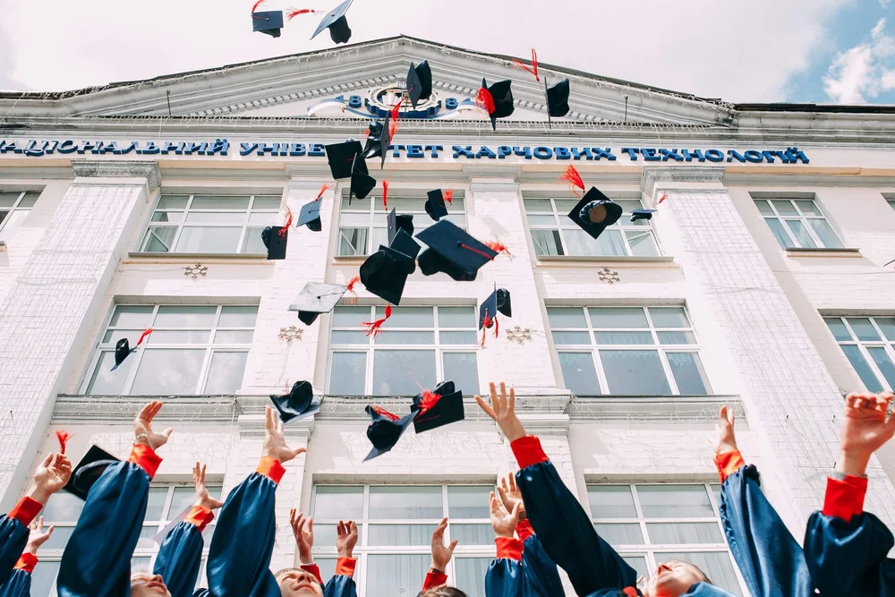 Graduates tossing caps in the air, a life transition supported by counseling at Anchor Therapy.