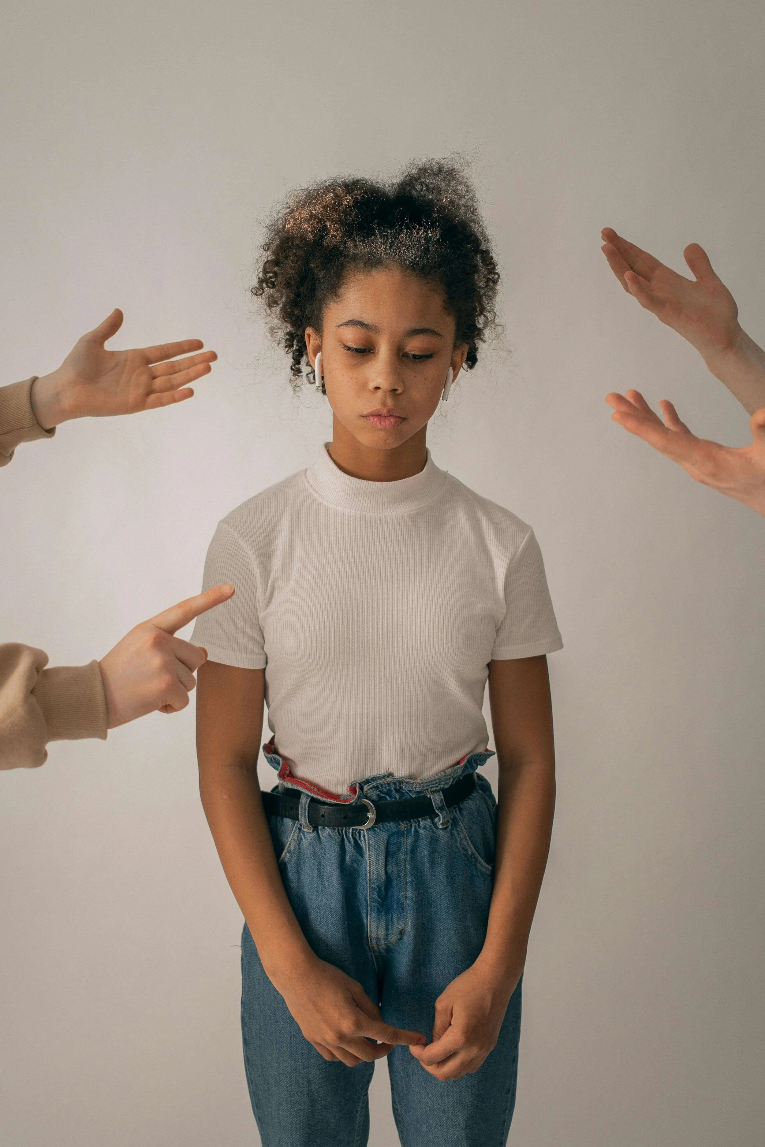 A sad child cast as the family scapegoat while relatives point blame around them, showing scapegoating in families, from a Hoboken NJ therapist