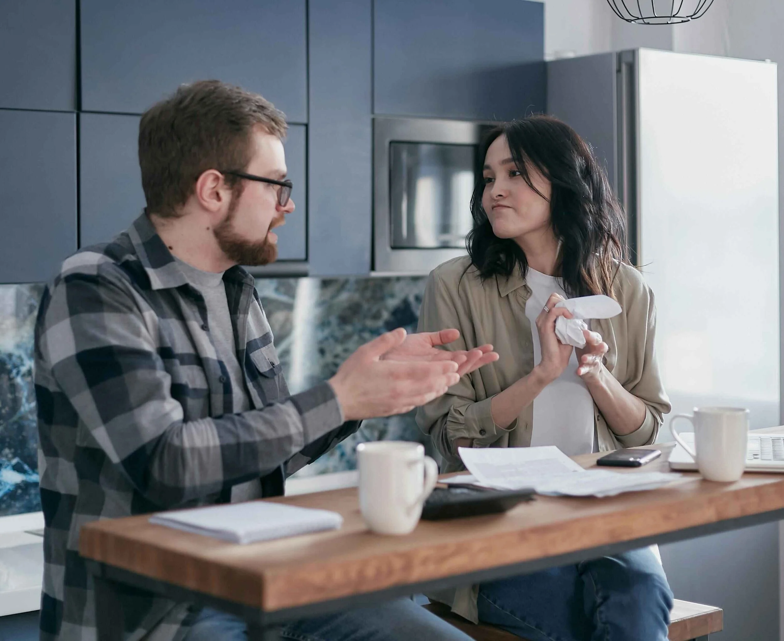 A couple sitting together reviewing bills and financial documents, seeking support for financial stress in their relationship from a couples therapist in Hoboken NJ