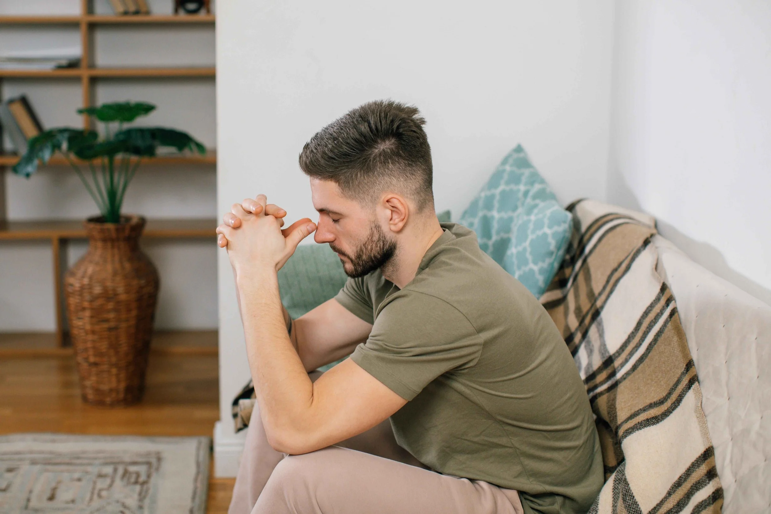 A man looking anxious and emotionally overwhelmed, experiencing the mental health effects of going through a breakup, working with a Jersey City NJ therapist