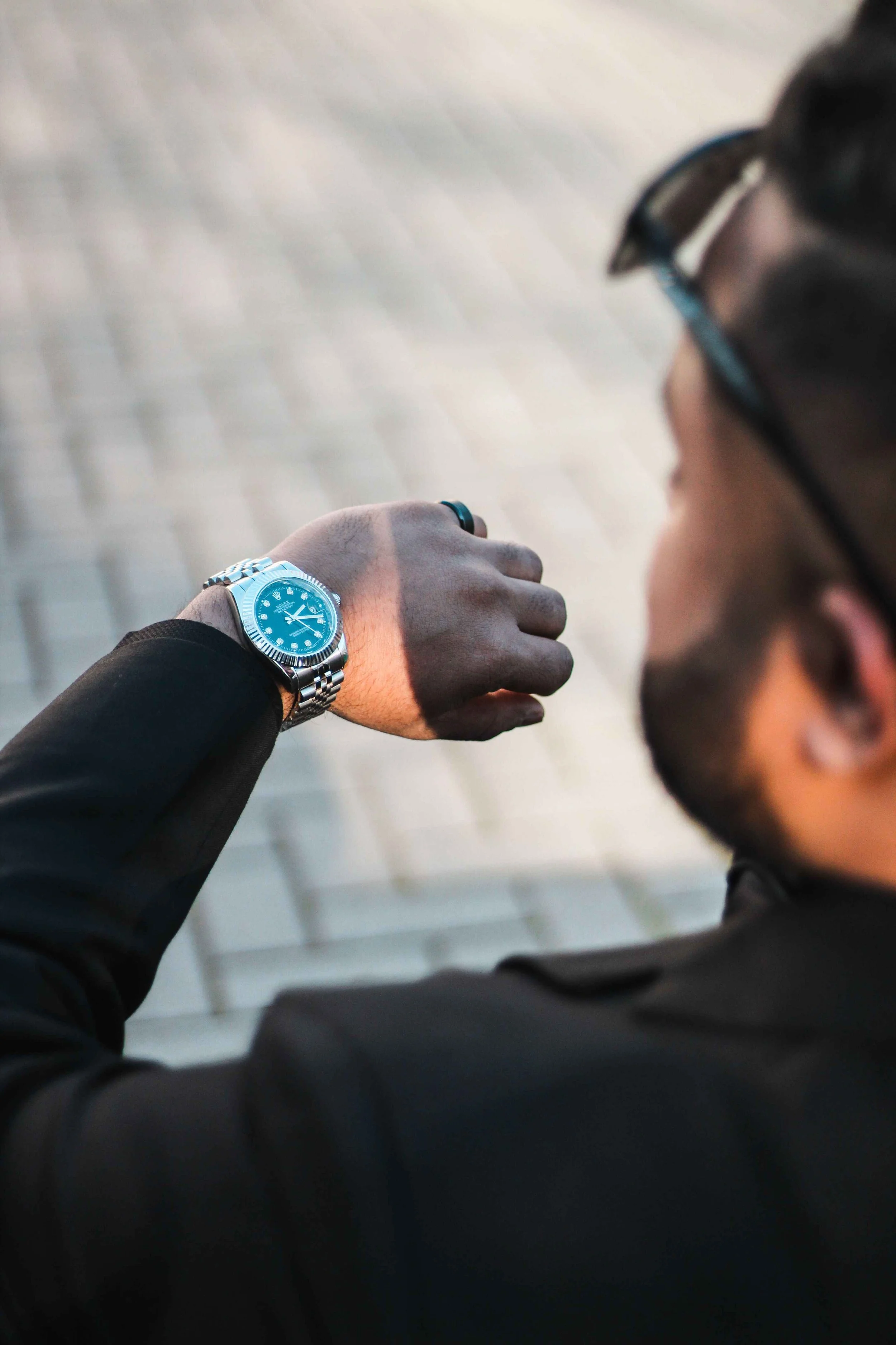 Man checking his watch while looking over his shoulder with Sunday night anxiety about the week ahead, Hoboken NJ therapist
