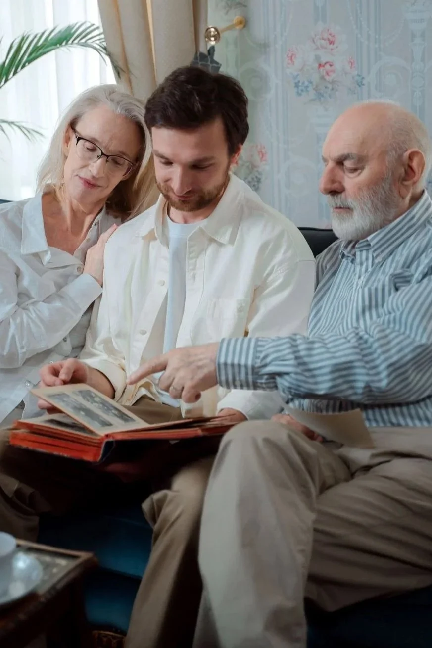 Three generations of a family looking through an old photo album together, no contact with parents trend Hoboken NJ counselor