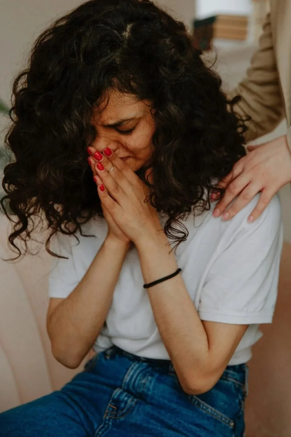 A woman crying while processing grief from a complicated relationship, seeking grief counseling support in New Jersey