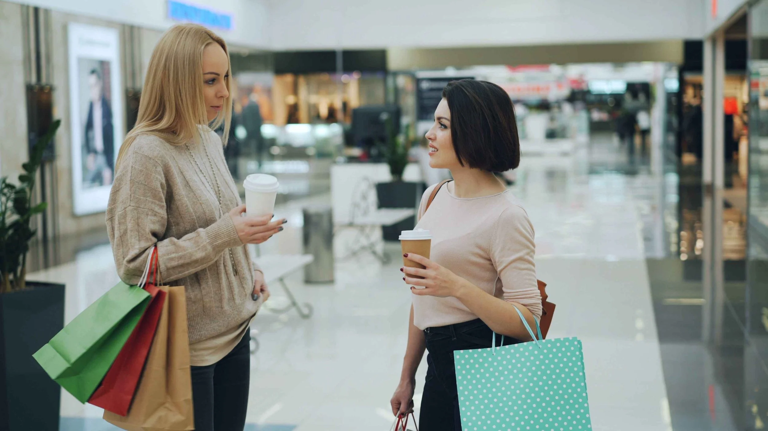 Two women talking while shopping, one with a serious expression, an example of friendship jealousy between close friends, Hoboken NJ therapist