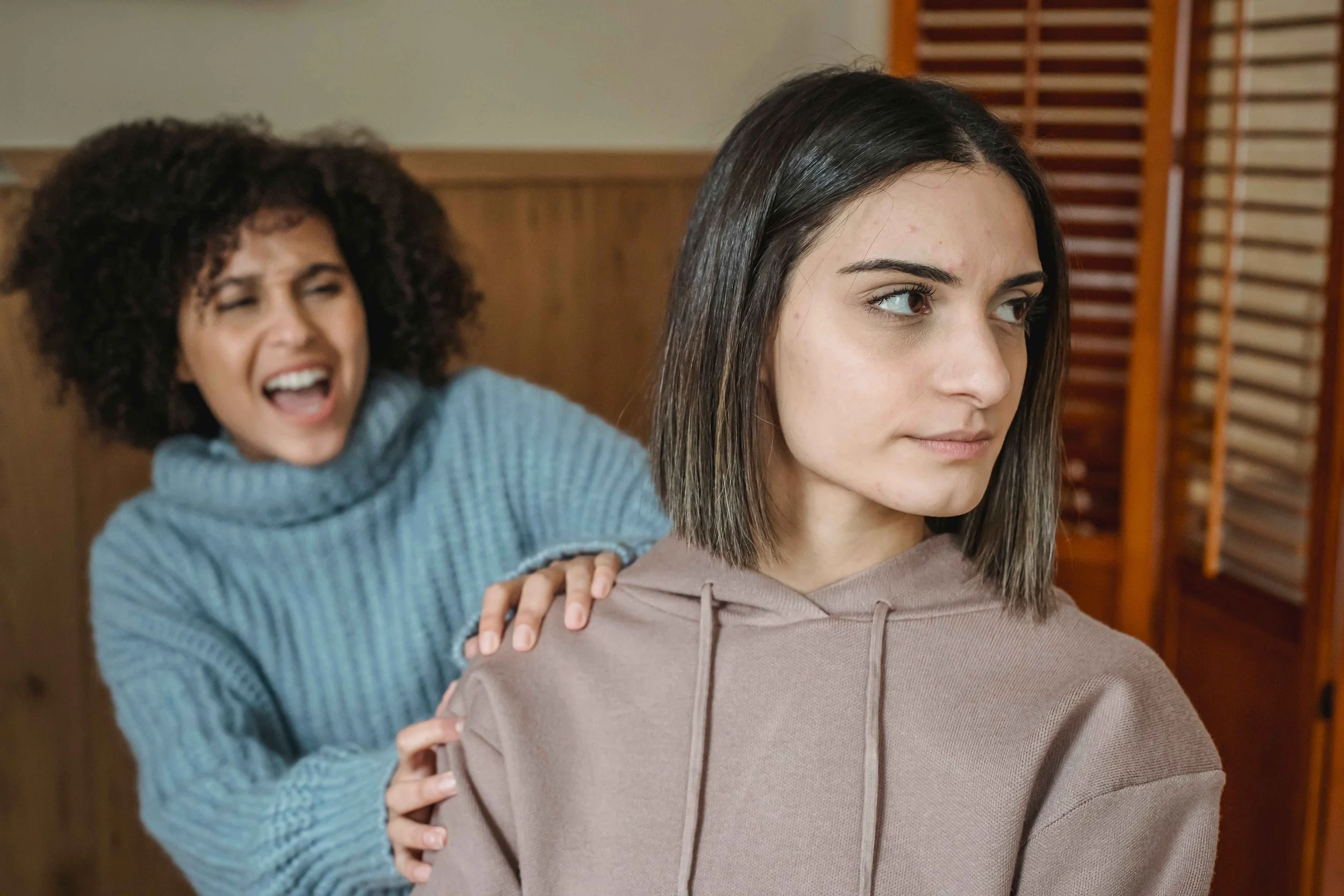 Two adult siblings sitting apart in silence after a falling out, Hoboken NJ family therapist