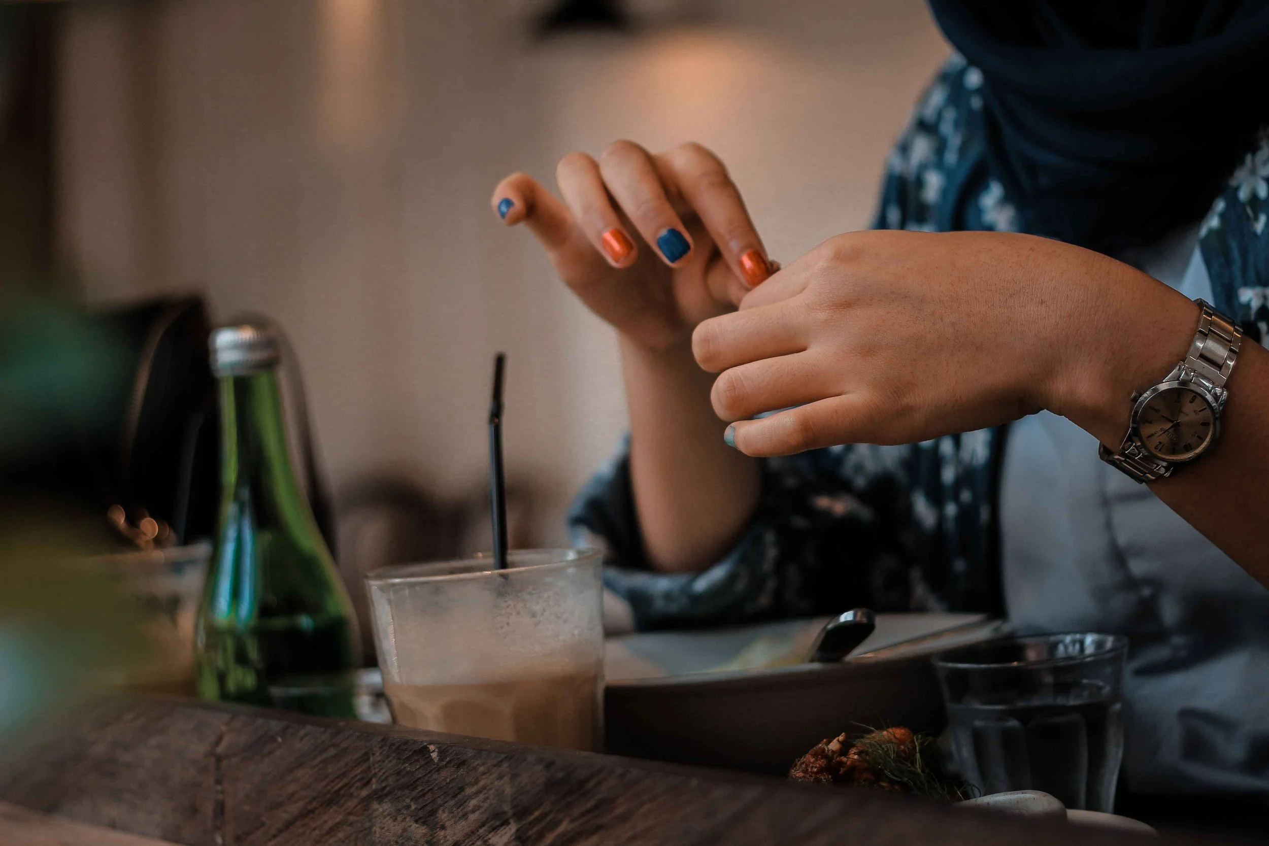 Close-up of a hand touching fingers together at a table, an example of checking a physical sensation in sensorimotor OCD, Hoboken NJ therapist