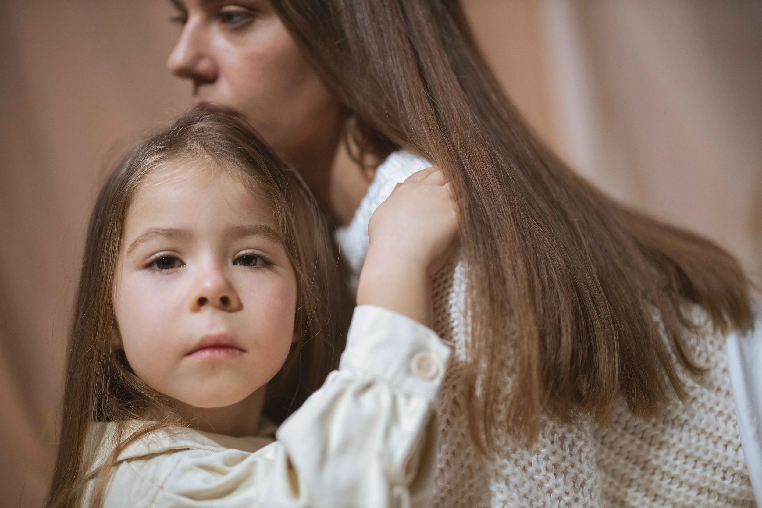 Young girl watching her mother closely in Hoboken, a common visual of parentification in childhood