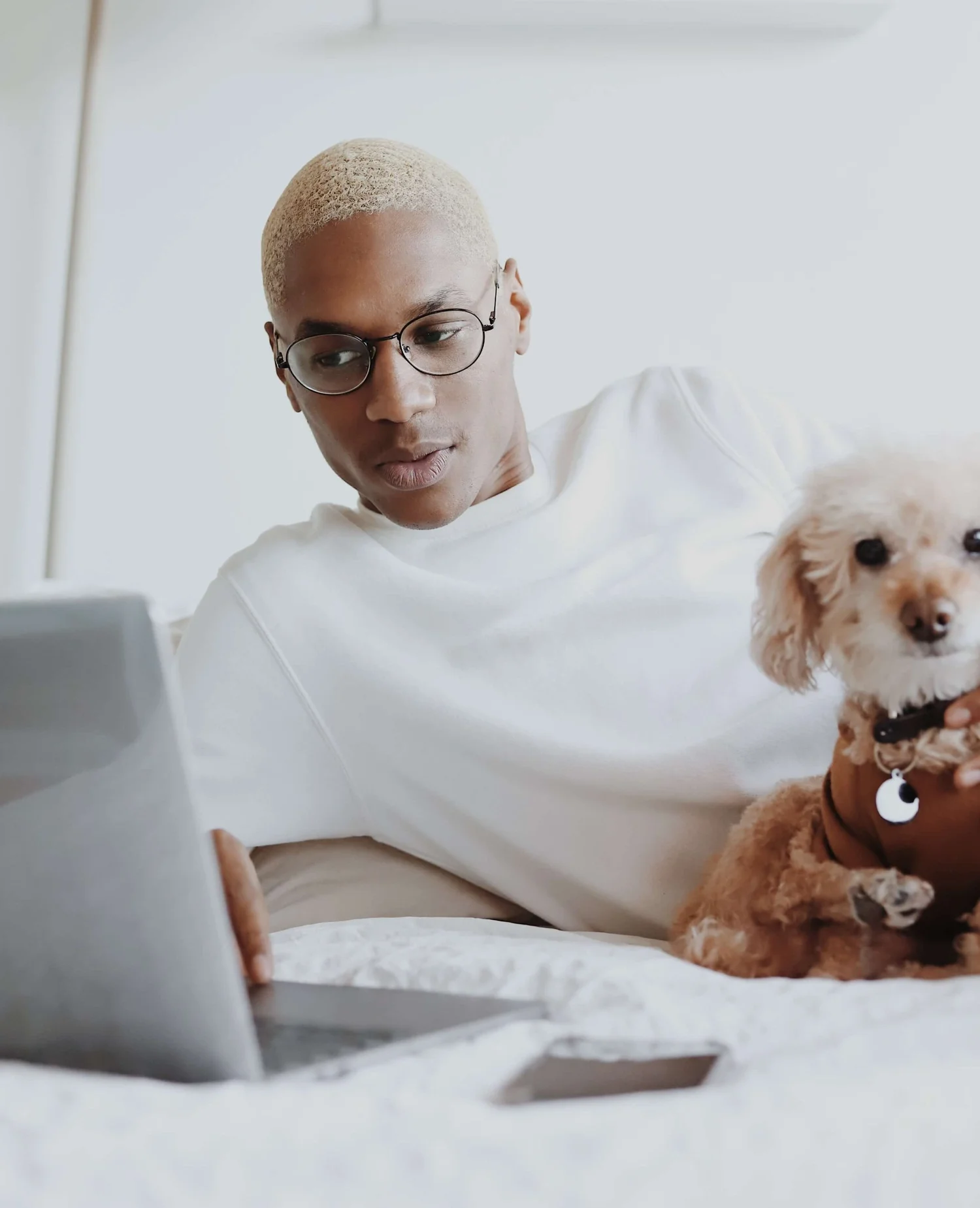 A man having an online therapy session on his laptop at home with his dog beside him, illustrating telehealth in NJ, NY and FL