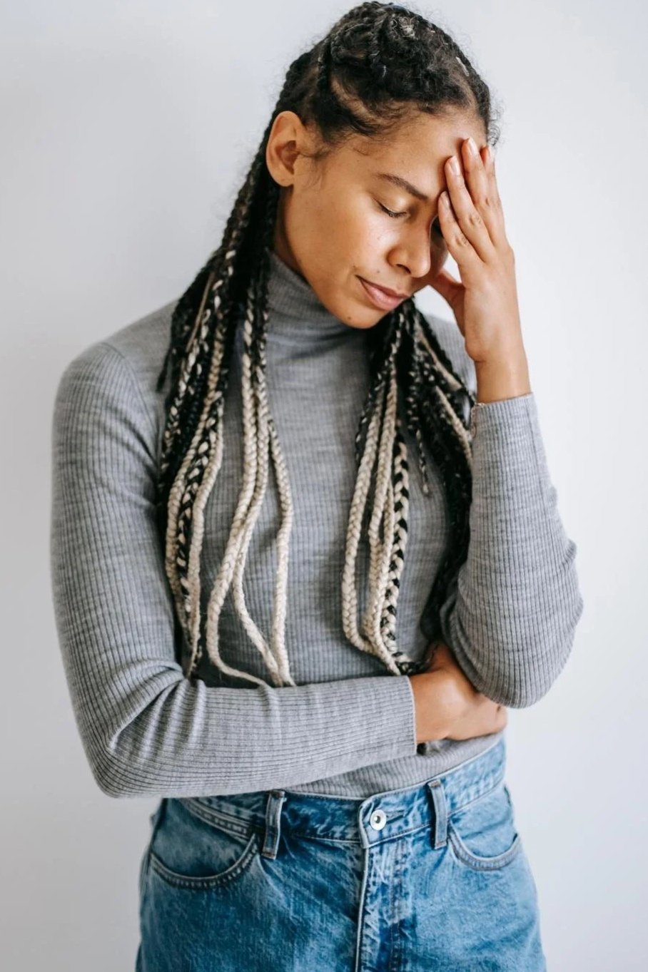 Woman holding her forehead in distress, an example of the anxiety scrupulosity OCD causes, Hoboken NJ therapist