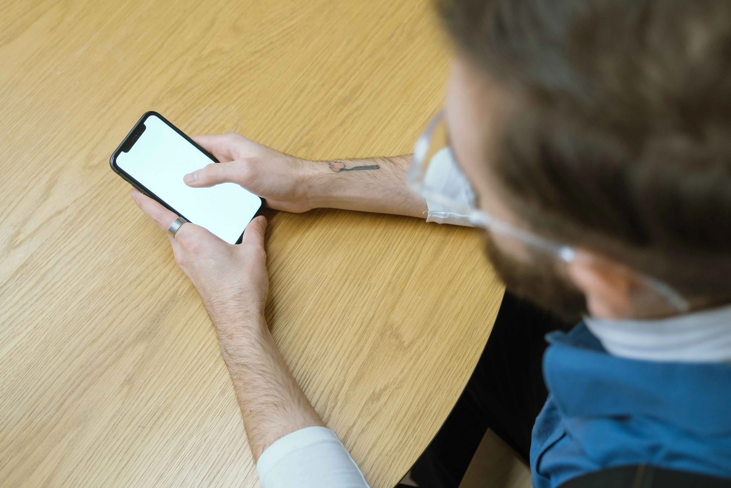 Man checking an unexpected text message at a table, flying monkeys meaning Hoboken NJ therapist