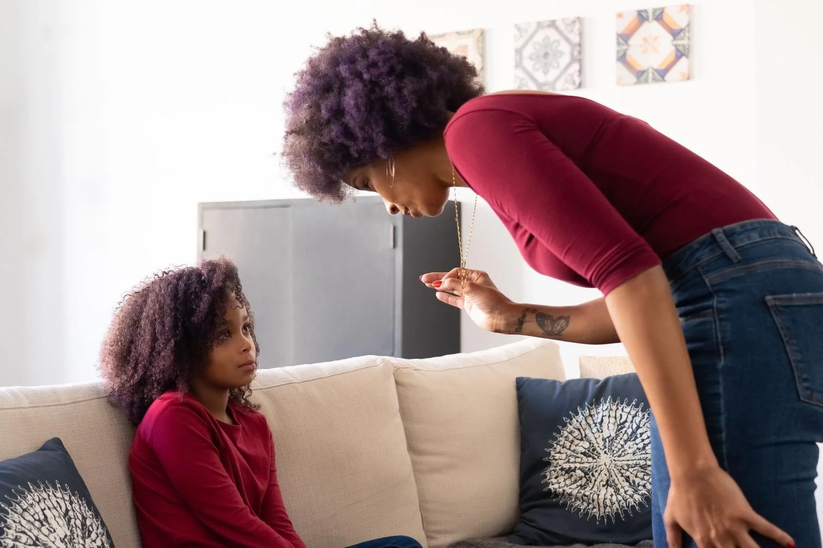 Mother leaning over her daughter on a couch during a tense conversation, setting boundaries with narcissistic parents Hoboken NJ counselor